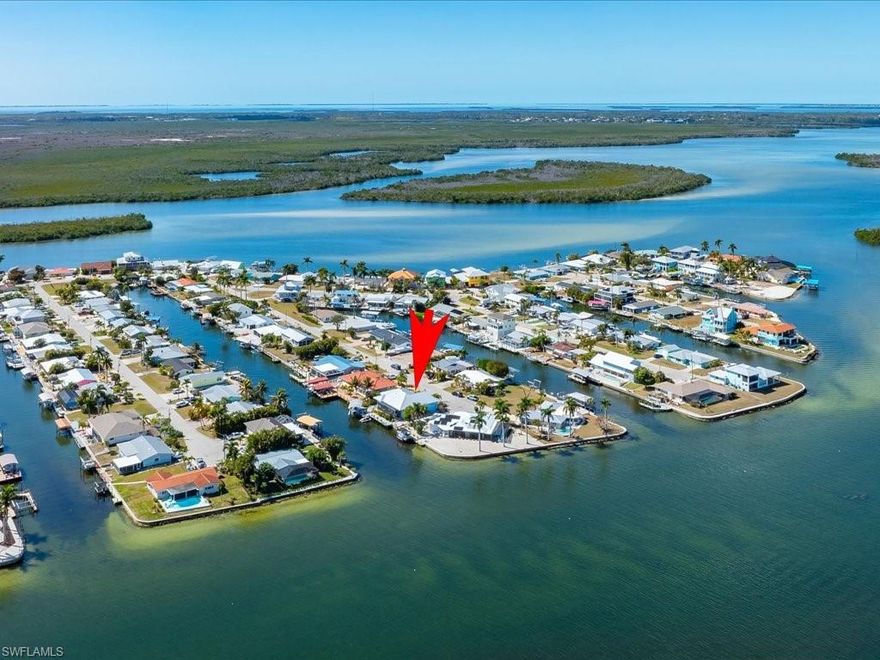 Direct Gulf access with panoramic bay views and protected canal docking in the heart of Matlacha. This custom 4 bedroom, 3 bath waterfront residence built in 2017 under modern Florida building codes offers elevated construction, quality design, and an exceptional boating lifestyle location. Offering 2,248 square feet of thoughtfully designed living space, the open concept floor plan features soaring ceilings, expansive glass sliders, porcelain plank tile flooring, plantation shutters, and impact rated windows showcasing sparkling water views from multiple living areas. The designer kitchen blends function and style with granite countertops, white wood cabinetry, stainless steel appliances, breakfast bar seating, and two farmhouse sinks creating a natural gathering space for entertaining and everyday living. The split bedroom layout provides privacy and flexibility while the spacious primary suite includes a private sitting area or den created by an easily removable wall that was originally designed as an expansive 19.6 x 13.5 retreat. Bathrooms feature upgraded tilework and modern finishes. Outdoor living captures the waterfront lifestyle with a lanai overlooking the protected canal and wide bay beyond, ideal for peaceful sunrise mornings and evenings with stars and moonlight reflecting across the water. The private 75 foot composite dock includes a boat lift with canopy, captain’s walk, and jet ski floating dock providing convenient boating access to Matlacha Pass, Pine Island Sound, and the Gulf of Mexico. A concrete seawall enhances shoreline durability and stability. Additional features include a metal roof, epoxy garage flooring, and architectural plans available. A rare opportunity to enjoy both protected docking and expansive bay views in one property. Located in vibrant Matlacha known for its art galleries, waterfront dining, boating culture, and laid back island charm. Seller reports no history of water intrusion.
