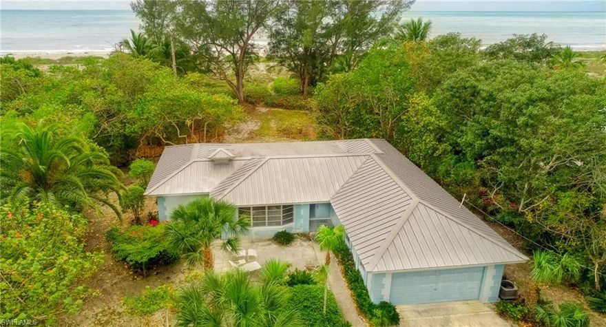 This little gem is nestled on more than an acre, deep at the end of a quiet cul-de-sac and surrounded by native vegetation to give you the ultimate private Sanibel sanctuary. Gentle natural light welcomes you into a home with a real mid-century vibe.  Cool terrazzo floors throughout, built-in bookcases for your library, and a bright, open feeling in every room.  Stroll down the path and relax in the shade of whispering trees as you enjoy the expansive view from your 100ft-plus beach front.  Or enjoy the sunsets from the lanai where the floor-to-ceiling windows and glass doors provide a spectacular ocean view.  Fully furnished. A/C replaced in 2017, new roof 2008. Electric hurricane shutters on lanai.