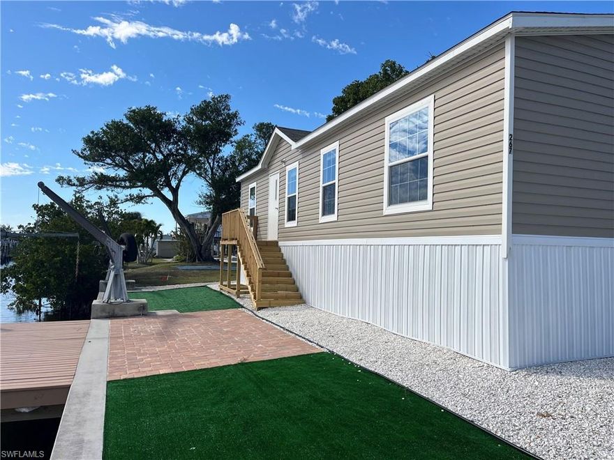 Your private tropical oasis awaits. This is a newer (2022), one owner, doublewide mobile home on a large 80'x90' waterfront lot. This home never had flooding or damage from any hurricane. It is elevated well above the flood zone and is secured by hurricane rated tie downs. The fenced lot features low maintenance landscaping for minimal effort and cost to keep looking great. You will enjoy your private dock and canal side patio right outside your door. In the back yard there is ample parking for your cars and recreational vehicles. You even have a private backyard putting green! The location offers quick, direct access by boat to Sanibel Island, North Captiva and Cayo Costa State Park, with its miles of deserted, white sand Florida beaches. By car you are minutes away from shopping, dining and entertainment both on and off the island. The septic system was new in 2019 and meets all code requirements. The seawall was built in 2016 and is in excellent condition. Great tenant in place currently paying $1800 per month. Lease through 7/31/26 but wants to stay if new owner would like.
