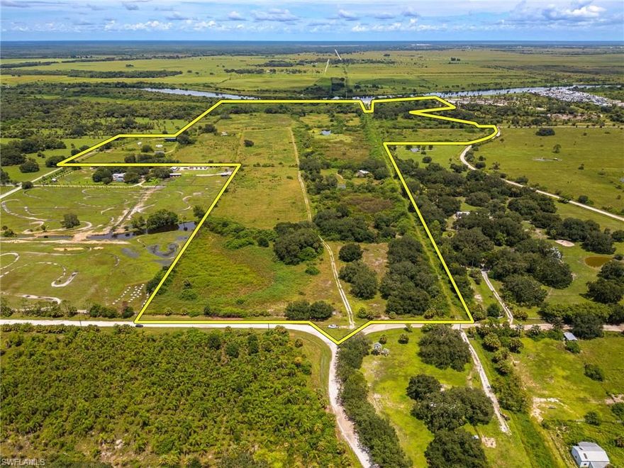 Opportunities like this are few and far between—115± contiguous acres on the Caloosahatchee River with nearly 1,900 feet of direct river frontage. Located in Glades County on Florida’s scenic Intracoastal Waterway, this property offers endless potential for a wide range of uses. The land is made up of six adjoining parcels and already has an existing well, septic, electric service, and a boat dock in place.

With multiple zoning allowances, this property can support agricultural operations, industrial applications, single-family residential development, recreational uses, or even mining opportunities. The scale and location of this tract make it suitable for larger visions as well—RV parks, equestrian facilities, farming, or a private estate. Investors will also appreciate that it is located in a Florida-designated Opportunity Zone (12043000200), offering the potential for significant tax advantages. An existing SFWMD permit adds to the readiness of this land for development.

A notable feature of the property is the existing Jecbo Canal, which runs the full north–south length of the acreage. If access approvals can be obtained from the U.S. Army Corps of Engineers and the South Florida Water Management District, the presence of this canal may allow for potential expansion. Such improvements could create the opportunity to develop interior waterfront residential lots—offering enhanced value, added water access, and increased design flexibility for future planning. Prospective buyers should conduct their own due diligence regarding all permitting requirements and development feasibility.

The Caloosahatchee River, stretching 154 miles from the Atlantic Ocean at Stuart to the Gulf of Mexico at Fort Myers, is one of Florida’s most desirable waterways, and this expansive acreage provides unmatched access to it. Whether you’re seeking a rare investment property, a multi-use development opportunity, or a private riverfront retreat, this property represents a truly exceptional offering in Southwest Florida.