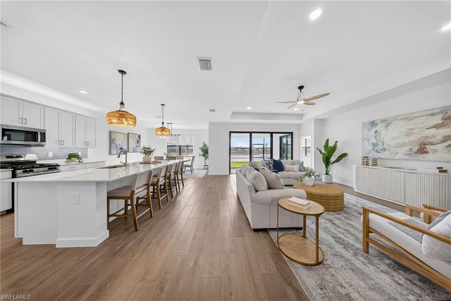 WIDE WATER VIEWS, NEVER LIVED IN, & the POPULAR SUMMERVILLE FLOOR PLAN + SELLER PAYS CLOSING COSTS! Positioned on a PRIME WATERFRONT HOMESITE in Verdana Village, this BRAND NEW 3 BEDROOM + DEN, 3 BATH residence offers 2,445 sqft of upgraded living without the wait for new construction! The EXPANSIVE REAR YARD captures peaceful SUNRISE VIEWS across the lake and offers room to create your own OUTDOOR OASIS with a custom pool (ask us for affordable quotes and renderings!).

Inside, the Summerville floor plan impresses with DOUBLE GLASS ENTRY DOORS, an OPEN CONCEPT LAYOUT, UPGRADED FINISHES, and PLANK WOOD-LOOK TILE throughout. FRESH COASTAL LIGHTING, DESIGNER CEILING FANS in the living room, bedrooms, den, and lanai, plus professional staging with the OPTION to purchase all FURNITURE SEPARATELY for an EASY MOVE-IN EXPERIENCE!

The kitchen features WHITE CABINETRY with SOFT-CLOSE CABINETS, UNDER-CABINET & OVER-CABINET LIGHTING, WHITE QUARTZ COUNTERTOPS, a BRAND NEW COASTAL TILE BACKSPLASH, CUSTOM PENDANT LIGHTING, a large island, MODERN DINING CHANDELIER, and all NATURAL GAS APPLIANCES. Natural gas service is rare to find in Southwest Florida!

Privately located at the rear of the home, the primary suite enjoys tranquil LAKE VIEWS, morning sun and direct lanai access. The spacious bath offers SPLIT DUAL VANITIES, QUARTZ COUNTERTOPS, a LARGE WALK-IN SHOWER, and TWO WALK-IN CLOSETS.

The split bedroom design includes a guest room with a full bath at the front of the home, while the second guest suite enjoys its own wing with a PRIVATE EN SUITE BATH and WALK-IN SHOWER—perfect for longer-term guests or anyone wanting their own space.

The DEN, with solid double doors, is ideal for a HOME OFFICE, MEDIA ROOM, or additional guest area.

Additional features include a laundry room with ADDED UPPER CABINETRY and a UTILITY SINK, plus a 3-CAR GARAGE with EPOXY FLOORING, a TANKLESS water heater, and plenty of room for storage, beach gear, bicycles, and a golf cart.

Residents of Verdana Village enjoy RESORT-STYLE POOLS, a FITNESS CENTER, INDOOR & OUTDOOR PICKLEBALL, TENNIS, BASKETBALL, BOCCE, a PLAYGROUND, DOG PARK, RESTAURANT, CAFE, and CRAFT COCKTAIL BAR.

Just outside the gates is a brand-new Publix plaza featuring Dunkin’, a UPS Store, nail and hair salons, physical therapy, a dentist, fine Italian dining, and a bank coming soon! Yes, you can grocery shop from your golf cart!

Minutes from Old Corkscrew Golf Club, Stoneybrook Golf Club, Miromar Outlets, Gulf Coast Town Center, and approximately 20 minutes from Southwest Florida International Airport.

The seller is offering assistance with buyer closing costs, and with all the upgrades already done plus the option to purchase the furniture, this is an easy, move-right-in opportunity!!!
One or more photo(s) has been virtually staged, AI generated or rendered.