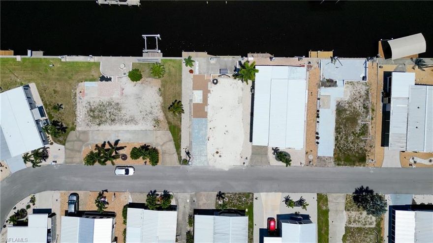 GULF-ACCESS LOT 118x84 on Saltwater canal located in Pine Island Cove 55+ community where you own the land. Home that was on the lot has been removed and lot is clean, ready for your new home. There is a hook up for electric, water, sewer and no impact fees. There is a paved curved driveway, beautiful landscape, cement patio, 2 docks, boat lift, davits & fish cleaning station. Community has heated saltwater pool, spa, private boat ramp, boat & RV storage, picnic area, clubhouse, dog run, fish cleaning station & a washout facility. There are lot of activities for everyone, pickleball bocce and more. Just a few minutes out to some of the best fishing in SW Florida or a trip to Sanibel, Cabbage Key or the beach at Cayo Casta.