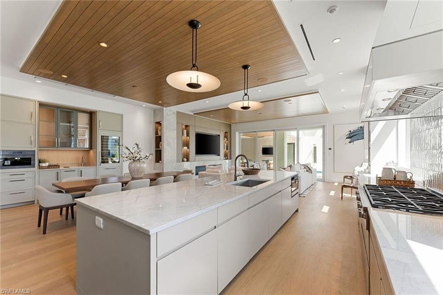 A masterfully crafted collaboration between Jeffrey Fisher Home, renowned architect JMDG, and the highly respected Waterside Builders; this newly completed Olde Naples residence blends elevated design with luxurious livability—just four blocks to the beach and two blocks from the charm of 3rd Street South. Every element of the home reflects attention to detail and timeless sophistication: European white oak floors, custom cabinetry and millwork, floor-to-ceiling glass, and intricate stained oak architectural ceilings. The open-concept floor plan flows through a sunlit study, elegant dining space, and stunning backlit bar into a designer kitchen outfitted with Miele, Wolf, and Sub-Zero appliances, plus a walk in pantry and first-floor laundry. The first-floor primary suite is a true retreat with immediate access to the pool and outdoor living areas. Framed by impact sliders, the living room opens to multiple covered spaces and a plunge / dipping pool and spa. A full summer kitchen and expansive outdoor deck make entertaining effortless. Upstairs offers exceptional flexibility and privacy with three en-suite bedrooms, a large bonus room, a second laundry, and a VIP guest suite. Control4 home automation, generator, natural gas, and electric roll-down screens and shutters provide ultimate comfort, security, and convenience. Positioned in one of the most sought-after pockets of Olde Naples, this bespoke property is a rare opportunity to own a truly exceptional new-construction home—steps from the Gulf, fine dining, and world-class shopping.