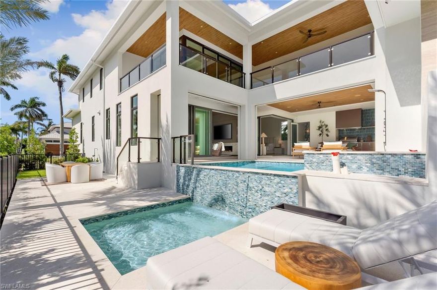 A masterfully crafted collaboration between Jeffrey Fisher Home, renowned architect JMDG, and the highly respected Waterside Builders; this newly completed Olde Naples residence blends elevated design with luxurious livability—just four blocks to the beach and two blocks from the charm of 3rd Street South. Every element of the home reflects attention to detail and timeless sophistication: European white oak floors, custom cabinetry and millwork, floor-to-ceiling glass, and intricate stained oak architectural ceilings. The open-concept floor plan flows through a sunlit study, elegant dining space, and stunning backlit bar into a designer kitchen outfitted with Miele, Wolf, and Sub-Zero appliances, plus a walk in pantry and first-floor laundry. The first-floor primary suite is a true retreat with immediate access to the pool and outdoor living areas. Framed by impact sliders, the living room opens to multiple covered spaces and a plunge / dipping pool and spa. A full summer kitchen and expansive outdoor deck make entertaining effortless. Upstairs offers exceptional flexibility and privacy with three en-suite bedrooms, a large bonus room, a second laundry, and a VIP guest suite. Control4 home automation, generator, natural gas, and electric roll-down screens and shutters provide ultimate comfort, security, and convenience. Positioned in one of the most sought-after pockets of Olde Naples, this bespoke property is a rare opportunity to own a truly exceptional new-construction home—steps from the Gulf, fine dining, and world-class shopping.