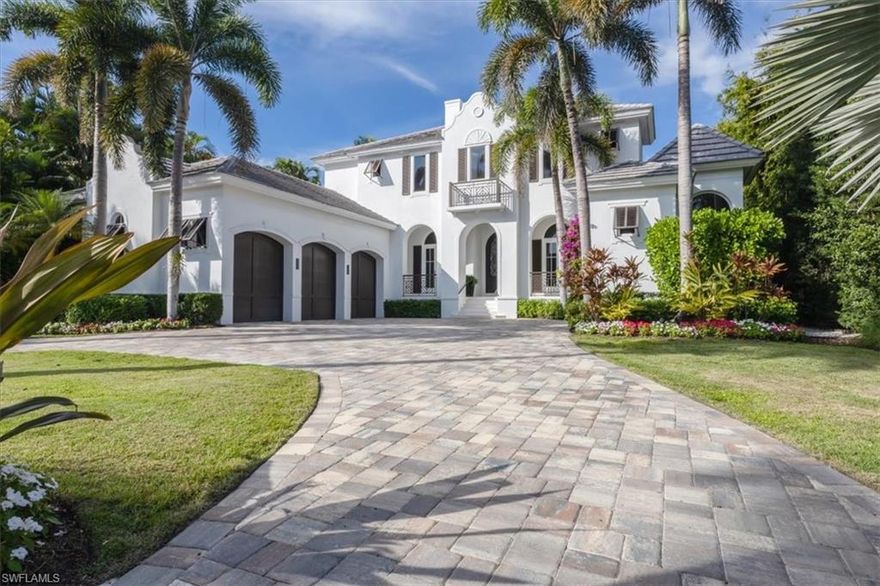 Welcome to Florida living at its finest. From the moment you enter this Coastal-style residence, breathtaking, unobstructed views of Crayton Cove and Naples Bay create an unforgettable first impression that never fades. Soaring ceilings, granite tile and new hardwood floors, designer lighting, and fresh interior and exterior paint set the tone for refined coastal elegance throughout.  The updated kitchen and luxurious primary suite—complete with a spa-inspired bath, floating soaking tub, and stunning walk-in closet—are just a few of the many thoughtful enhancements in this exceptional home. Offering nearly 7,700 total square feet, the residence features four bedrooms plus an office, four full and two half baths, a spacious media room, and a private elevator.
The great room opens seamlessly to the outdoors through full-corner hurricane-impact sliding doors, creating effortless indoor-outdoor living. Enjoy the first-floor infinity pool deck as boats glide by en route to the Naples Yacht Club, or embrace the ultimate boating lifestyle with direct Gulf access and no bridges. The new 24,000-lb covered boat lift, double jet-ski lift, and 50-amp shore power complete this boater’s paradise. A three-car garage with air conditioning and two custom 6,000-lb car lifts adds exceptional convenience.  Unwind on the second-level terrace with new Ipe wood decking while taking in iconic Naples sunsets, or practice your short game on the private putting green—all surrounded by spectacular water views. Designed for luxurious living and unforgettable entertaining, this one-of-a-kind waterfront residence delivers the very best of the Naples lifestyle.