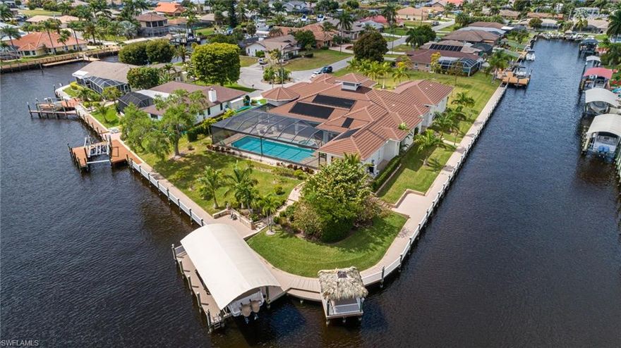 One of a kind! This may just be the largest Sailboat access property in Cape Coral! Enjoy your own park with over 400 ft of water-frontage and expansive water views in all directions. Situated on almost one acre point lot, just a stone throw from the Caloosahatchee River the builders had space in mind... Welcoming sprawling lawns, circular driveway, gazebo, and inviting grand entrance with porch sitting area will wow you! Great room design featuring pocket sliders merging the indoor living space with the expansive outdoor areas. Two master suites are located pool side and the guest bedrooms with ensuite bathrooms are generous in size with walk in closets. Gourmet kitchen has large walk in pantry and top of the line appliances, it also opens to the outdoor dining and entertainment areas. Oversized saltwater pool and spa have solar and electric heat for year round enjoyment. There is a 400ft captains walk with Tiki hut and canapé boat lift framing this unique piece of property with pergola fire pit, beautiful landscaping and select exotic trees. This is the perfect location or the serious boater... and there is an air-conditioned garage for the luxury car lover too!