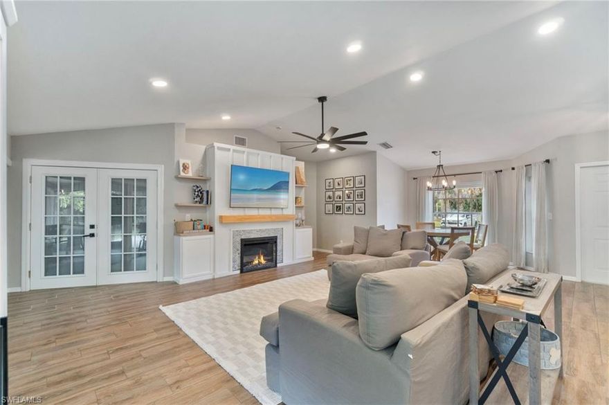 Welcome HOME to your private Golden Gate Estates retreat! Nestled on 2.27 acres of manicured land, this 3bed/2bath gem perfectly blends comfort and modern design. Ideally located in sought-after Golden Gate Estates location, just off Golden Gate Boulevard! Tucked away from the road, this updated property offers extra privacy and curb appeal. Step inside to a welcoming living area featuring vaulted ceilings and a custom feature wall with a built-in electric fireplace and TV (included) - a stunning focal point for both relaxation and entertaining. The open-concept kitchen has been tastefully updated with soft close shaker cabinets, upgraded counters, and stainless steel appliances. Both bathrooms have also been beautifully renovated. Enjoy peace of mind with major recent upgrades to include a NEW METAL ROOF (2024), NEW PEX PLUMBING (2020), and a newer water heater (2019). The home is also equipped with a whole-home Reverse Osmosis System so you can ensure pure water throughout. Additional features include wood plank tile flooring, updated light fixtures, newer interior and exterior paint, newer A/C ductwork, a property fence, a charming shiplap accent wall in the guest bedroom, and a comfortably-sized laundry room with storage space. Relax on the expansive screened-in lanai and enjoy your morning coffee surrounded by nature! This darling home truly delivers all the good vibes; see it today! PLEASE NOTE: The home is insulated foam concrete block with vinyl siding and the garage is wood frame.