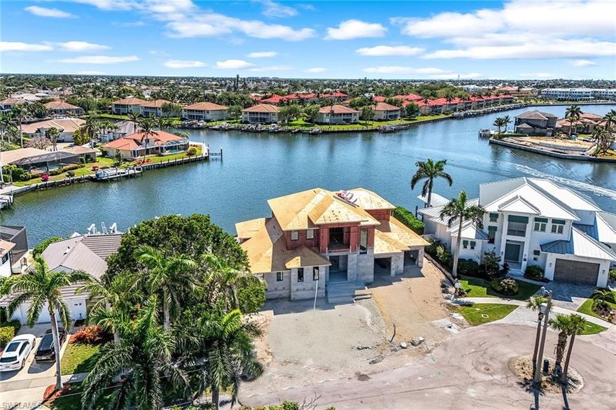 Immerse yourself in the epitome of coastal contemporary living with this exquisite two-story custom-built home, offering four bedrooms, four baths and a den. On a picturesque lot with stunning converging wide water views, this residence is a haven for the boating enthusiast, providing easy access to the Gulf of Mexico with the raised Smokehouse Bridge and on a tranquil cul-de-sac. A spacious open great room with soaring high ceilings, seamlessly blending into a gourmet kitchen. This culinary masterpiece features an island, breakfast bar, custom cabinetry, top-of-the-line Thermador appliances, a six-burner gas range and a separate dining area. The primary suite retreat, on the first floor, offers ultimate comfort and luxury. Additional guest bedrooms on the second floor include a loft, a wet bar and a private balcony, providing a getaway for visitors. The expansive open lanai with a pool, spa, summer kitchen, sun deck and gas fireplace are ideal for entertainment and relaxation, allowing you to indulge in sparkling wide water views. This home is equipped with impact windows and doors, electric shutters for the covered lanai, rolldown screens, generator and propane tank. A new seawall was completed in April 2024, ensuring peace of mind and longevity. Convenient to all Marco Island has to offer, this residence boasts an estimated completion date of March / April 2026, promising a modern, luxurious lifestyle in a great location.