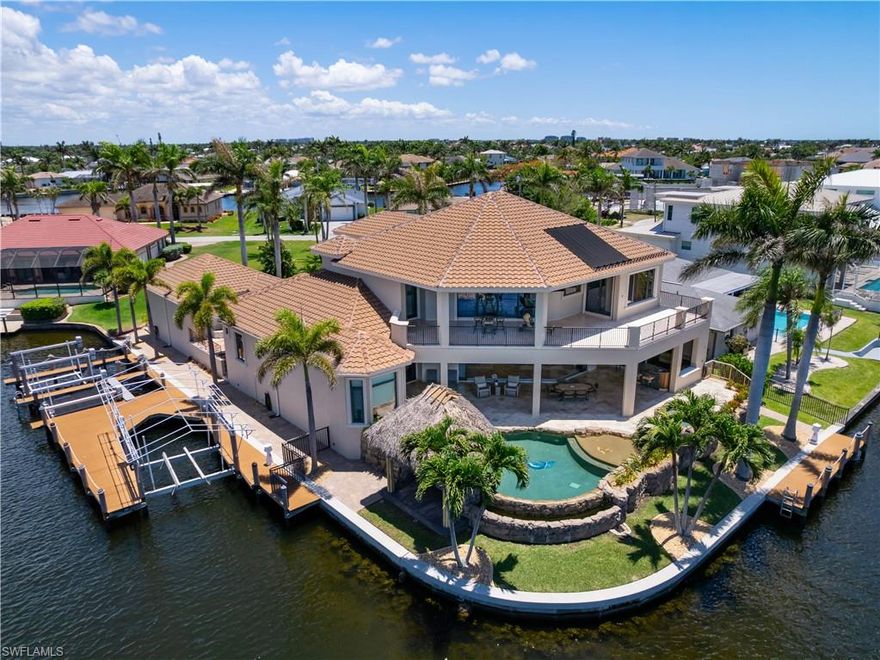 A Truly Special Koogler Built Home on One of Cape Coral’s Largest Canals Positioned at the end of a quiet cul de sac on a rare corner lot, this beautifully crafted Koogler home offers 4,473 square feet of living space and more than 200 feet of waterfront along a 200 foot wide intersecting canal. It is one of the most impressive settings in all of Cape Coral, and the home has been cared for by the same owner since it was built. The interior features custom built cabinetry in the kitchen and bathrooms, a gas Wolf cooktop, a brand new Thermador refrigerator and thoughtful craftsmanship throughout. The first floor showcases beautiful wood beamed coffered ceilings that bring warmth and character to the main living areas. Zero corner pocket sliders open the home seamlessly to the outdoors, allowing the water to become part of the living experience. The layout includes 4 spacious bedrooms and 7 bathrooms, along with a private movie theatre and a full Control4 smart home automation system. Both the interior and exterior have been freshly painted, giving the home a clean and updated feel while still honoring its original design. The outdoor living area is one of the true highlights of the property. The wide open views across the enormous canal create a peaceful and private backdrop. With more than 200 feet of frontage and 3 boat lifts (16k, 7k & 7k), the home offers unmatched space and access for boating and waterfront living. A large 3 car garage provides extensive room for vehicles, storage and hobbies. The seperate garage can hold 2 car lifts. Everywhere you look, the quality of Koogler Homes is clear, from the construction to the finishes that have stood the test of time. This is a one of a kind opportunity to own a carefully maintained home on one of Cape Coral’s most extraordinary waterways. A rare combination of setting, craftsmanship and pride of ownership that is not easily found.