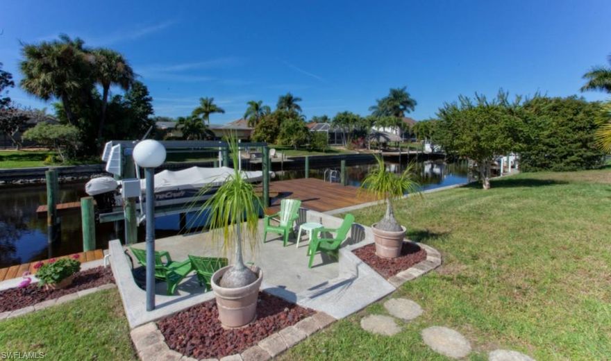HUGE PRICE REDUCTION The perfect location for you & your boat, direct access & 7000 pound boat lift, water & electric at dock with an extended wood deck to enjoy Gorgeous western sunsets. The Cape Coral Yacht Club Beach has a  Restaurant overlooks the beach, gas dock, come by boat, a fishing pier too all within walking distance of your new home. Sidewalks &  bike paths are a plus in the Yacht Club neighborhood. The tropical landscape includes  honey bell fruit tree, plenty of room for a pool. There is a patio to enjoy the outdoors. As you enter your new home a large great room draws you to the waterfront. There are windows everywhere to enjoy the sunshine too. 2 master suites one has shower only, the other has tub/shower. The galley style kitchen is neat as a pin, a great breakfast area surrounded by windows to enjoy the water views. Updates include new roof 2005, new flat roof 2011, AC inside & out side unit in 2002. This home is a pleasure to show, you don't need to do a thing but relax and enjoy the Florida lifestyle. Land value is here, no need to tear this one down, it is a gem in perfect condition. Window shutters for extra protection & location make this just right for you.