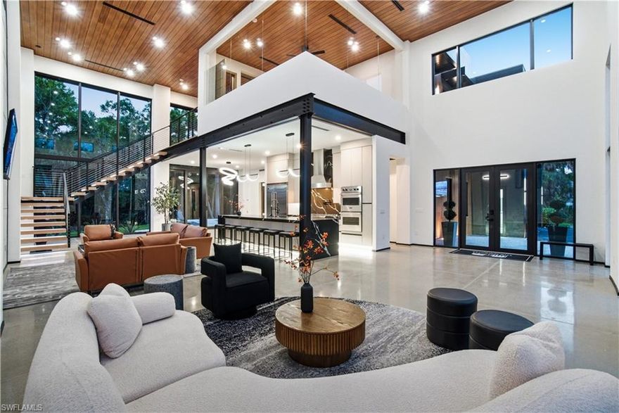 This isn’t coastal soft.
This is steel, concrete, wood, and glass. Volume. Texture. Intention.

This is not merely a house — it is the destination.

A triumph of design, craftsmanship, and architectural audacity, 27100 Imperial Parkway is a nearly 5,000-square-foot residence under air (over 7,000 total!) set on a private acre of natural preserve. Completed in 2026, this one-of-a-kind modern sanctuary fuses precision engineering with warm livability — bold yet refined, dramatic yet deeply intentional.

Imagine total privacy, buffered by nature, while remaining moments from world-class coastal dining, shopping, and entertainment. Secluded — but never disconnected. Upon arrival, a grand entrance with soaring 22-foot ceilings immediately establishes the scale. Natural light pours through expansive walls of glass, illuminating sculptural interiors defined by clean lines and curated materials. Two floating staircases — each step individually LED-illuminated — function as architectural art. Exposed steel beams add industrial edge, softened by warm woods and bespoke finishes. Designed for elevated entertaining, the chef’s kitchen features top-tier Viking appliances, custom cabinetry, and statement fixtures. A separate guest suite or executive office with it's own private entrance, private bath and sleek wet bar offers flexibility without compromise. Luxury is found in the details: solid-core doors, a designer lighting package, custom built-ins with integrated LED accents, and even a discreet laundry chute from the primary suite. Every element has been considered.

Then the walls disappear.

An entire expanse of glass opens to a private outdoor oasis where stone decking surrounds a striking pool and expansive covered terrace. The preserve beyond becomes living artwork — tranquil, protected, and ever-changing. Above it all, a rooftop deck offers the ultimate vantage point for sunset cocktails and stargazing.

Built with enduring quality, including a commercial-grade TPO roof and impact glass throughout, this residence is as structurally impressive as it is visually stunning.

For the automotive enthusiast, the property is nothing short of extraordinary. A massive driveway, elegant stainless steel water sculpture, and an enormous garage designed to astonish — featuring towering impact-glass doors and ceilings with unique hexagon LED lighting, designed to accommodate lifts, allowing the five-car garage to hold up to ten vehicles. Boaters and RV owners will find ample parking as well. 

Located just about a mile from Imperial 41 and Sugar Shack and a short drive to downtown Bonita, this architectural masterpiece offers rare proximity to convenience while preserving complete privacy.

Agent-accompanied showings by appointment only.
Experience a residence where design is deliberate, luxury is effortless, and living is elevated.