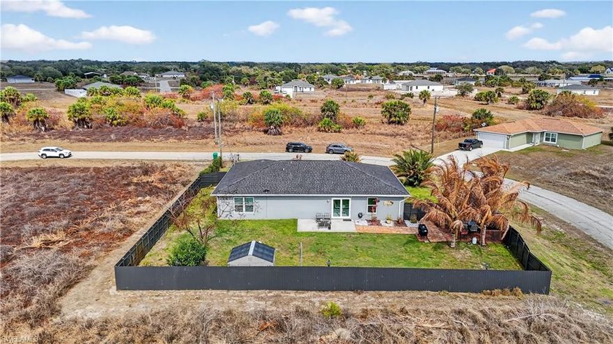 Beautifully maintained one-story single-family home, situated on an oversized 12,197 sq ft corner lot with NO HOA,  featuring 3 bedrooms, 2 full bathrooms, and a 2-car garage. The home offers a bright, open-concept layout where the living room, dining area, and kitchen flow seamlessly—perfect for everyday living and entertaining. The desirable split-bedroom floor plan provides added privacy, while large windows allow abundant natural light to fill every room. This property offers exceptional flexibility and space. The fully fenced backyard is a private retreat featuring a large access gate ideal for storing a boat, camper, trailer, or additional vehicles. A storage shed and custom gazebo add both convenience and charm, creating the perfect setting for outdoor relaxation and gatherings. Interior upgrades include impact-resistant insulated windows and doors, granite countertops, solid wood cabinetry, and a welcoming front porch—ideal for enjoying peaceful mornings or beautiful sunset evenings. Enjoy the tranquility of this spacious property while remaining just a short drive from Southwest Florida’s stunning Gulf Coast beaches, as well as shopping, dining, and everyday conveniences. Don’t miss this opportunity to own a versatile and beautifully upgraded home