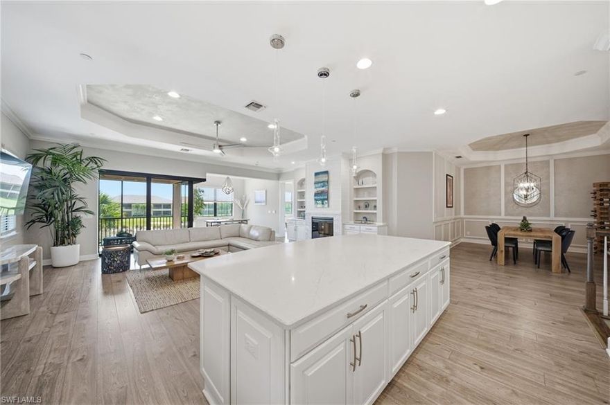 FULL GOLF MEMBERSHIP is included with this pristine and beautifully appointed Romano second-floor corner coach home, ideally situated on one of the most desirable streets within Esplanade Golf & CC. This highly sought-after end unit offers 2,393 square feet of refined living space, featuring 3 bedrooms, 3 bathrooms, and a spacious den that can easily function as a home office or formal dining room. Thoughtfully upgraded throughout, the residence showcases a neutral color palette that seamlessly blends elegance and comfort, while capturing stunning sunsets, golf course and water views from the inviting lanai. Power shades enhance both the interior sliding glass doors and the lanai screen, adding convenience and style.
Inside, the open-concept great room is bright and welcoming, enhanced by additional windows that fill the space with natural light—an advantage unique to end units. Wainscoting and beautiful wood-style luxury vinyl flooring run throughout the home, complemented by custom built-in cabinetry and modern shelving that create a warm yet sophisticated ambiance. Crown molding and tray ceilings provide refined architectural detail, while a striking feature wall with tile surrounding the fireplace, shiplap accents above, and custom built-in bookshelves adds character and charm.
At the heart of the home, the kitchen is both functional and elegant, featuring a large quartz center island, GE stainless steel appliances—including a newer refrigerator and an induction range that has never been used—and abundant white cabinetry, making it ideal for both everyday living and entertaining. The spacious primary suite offers tranquil views, a custom-designed closet with generous storage, and a beautifully appointed modern bathroom. Each guest bedroom is well-sized and features its own private bathroom, ensuring comfort and privacy for family and visitors.
High-impact hurricane windows and doors provide added security and peace of mind, while designer lighting, premium finishes, and meticulous attention to detail further elevate the home’s appeal.
 
From the moment you arrive, it’s clear why the community earned the Outstanding Landscaping Award for its grand entrance from the National Association of Landscape Professionals.  Also, the lifestyle at Esplanade Golf & CC continues to elevate with a newly approved Capital Improvement Project (CIP) featuring four indoor pickleball courts, Bahama Bar enhancements, a redesigned golf course by Rees Jones, an expanded driving range, and an enlarged outdoor bar and kitchen at the clubhouse. Residents enjoy a true resort-style experience with championship golf, a state-of-the-art clubhouse, poolside dining, cabanas, tennis, pickleball, scenic trails, a dog park, fitness and wellness centers, a full-service spa and salon, and more—all ideally located in North Naples near top shopping, dining, and the airport. Come experience the Esplanade lifestyle now!