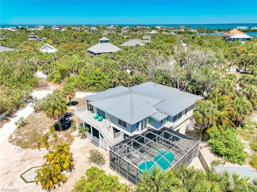 Rare 6-bedroom North Captiva Island Home with Screened Pool Area where Everyone Has a Place, and Every Moment Feels Like a Vacation!
Imagine arriving with a full house... family, friends, kids, grandparents... all under one roof, yet everyone has their own space to unwind. Mornings begin with coffee around the kitchen's breakfast bar to plan the upcoming day at the beach. Afternoons drift between the pool, BBQ area, game room, and shaded porch… and by evening, everyone gathers again, sharing stories over dinner as the island breeze moves through the lanai.
This beautifully designed 6-bedroom, 3.5-bath plan was made for togetherness without crowding, offering expansive open living spaces to connect with family, along with private retreats for quiet moments. The heart of the home is a large open-concept living, dining, and kitchen area where meals turn into memories and laughter carries long into the night. Outside is a large covered Key West-style front porch to perfect the island vibe. Just off the great room is a media room - perfect for movies and gaming any time of day. A spacious primary bedroom offers a sunny bay-window nook and an en-suite bath with a deep-soaking tub & shower combo. Three more guest rooms are just down the hall from the kitchen with a shared full bath.
Downstairs, a relaxed den and games room create a natural draw for kids & teens for late-night hangouts, or a great hangout for older parents who don't like lots of stairs. Two bedrooms and a full bath, plus a laundry center on this level, make it a second essential recreation and living hub of the house, with the screened pool area just outside. This level seamlessly blends indoor comfort with outdoor fun.
Step outside and the experience only gets better. A heated, screen-enclosed pool becomes the center of the day, surrounded by generous lounging and dining areas designed for long, unhurried afternoons. Just beyond, a separate poolside cabana with a wet bar and grilling station sets the stage for effortless entertaining—whether it's a casual lunch, sunset cocktails, or a full-on BBQ cookout. The exterior of the house was upgraded with a new standing seam metal roof in 2023.
Conveniently located just a short golf cart ride or walk from the ferry landing, Island Club amenities, and beach access.  Everything you need is within easy reach. Whether hosting multiple families, creating traditions for generations, or building a high-performing vacation rental designed for large groups, this is the kind of home where people come together and never want to leave. Take a closer look and start picturing your next gathering here.