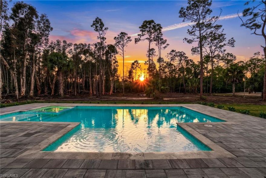 2025-CUSTOM-BUILT POOL HOME WITH 5 BEDROOMS & THE MOST STUNNING FINISHES, NESTLED ON A BEAUTIFULLY WOODED & PRIVATE 1.24 ACRE LOT IN BONITA SPRINGS’ COVETED “SAN CARLOS ESTATES!” This contemporary estate offers a stunning wooded nature view & prime Western exposure for spectacular sunsets & optimal sun on the brand new custom saltwater pool & spa with two sun shelves & bubbler features, situated on a nearly 1,700 sq ft pool deck with additional covered porch & outdoor kitchen adjacent. With an open & lofty floor plan of 2,845 sq ft under air & 4,333 sq ft under roof, this contemporary home boasts a spacious outdoor kitchen, soaring ceilings, Chef’s kitchen straight from a designer magazine, hurricane impact windows/sliders, metal roof, surround sound system, custom fireplace mantel, all solid surface flooring throughout & an oversized extra deep garage. The high-end kitchen boasts quartz counters & custom backsplash, custom dual-tone cabinetry in a modern taupe & rich brown woodgrain color palette, smart Café appliance suite including touch screen oven & double drawer dishwasher, walk-in pantry & adjacent bar with wine fridge. Fabulous entertainment deck offers a generous outdoor kitchen with granite counters, built-in gas grill & wine fridge. The master suite offers spacious dual walk-in closets & stunning bath with modern freestanding tub & oversized walk-in shower with frameless enclosure. The exterior is masterfully crafted with Bahama shutters, modern vertical stucco banding & shiplap accents & Southern-style front porch with modern cable railing. Residents of San Carlos Estates enjoy unparalleled space, privacy & nature with the best dining/shopping amenities just down the street. No HOA fees or rental restrictions! Peaceful living in a central location with easy access to US-41, Imperial Pkwy & I-75. 2 mins to the Promenade shopping/dining, less than 5 mins to Coconut Point, 15 mins to world-class beaches & 20 mins to RSW International Airport.