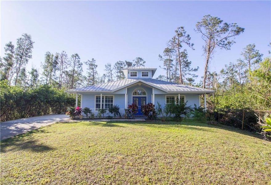 Delightful Key West style home is a breath of fresh air for the buyer who is tired of seeing the same old stucco house. Tucked away on a quiet wooded lot, at the end of a long paved driveway, the brightly colored home stands proudly among the pine trees. Durable Hardie board siding exterior, metal roof and wrap around porch all add to the charm. French doors welcome you into the large living room, with natural light streaming down from the cupola windows. Beautiful custom features include a wood burning fireplace with carved mantle and blue Mexican tile flooring throughout. Partially irrigated yard is fenced and gated, with fruit trees and room for pool or shop.