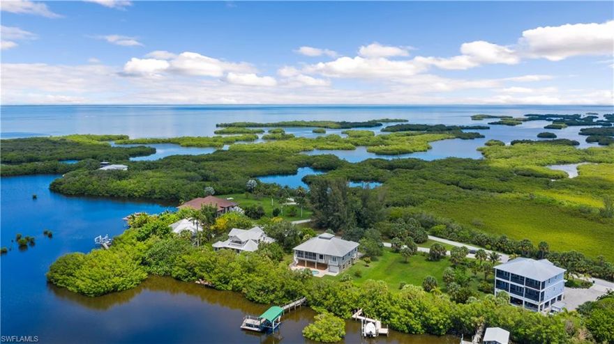 Rare home with 6-car garage plus lots of flex space underneath the nearly 2,700 sq ft of living at the edge of Chalotte Harbor. This secluded Pirate Harbor community provides quick boating access to the Gulf of Mexico, world class fishing, and renowned waters for sailing. Mangroves behind home can be trimmed to increase views of the water though current owners prefer privacy. This meticously maintained home has many exceptional features. An elevator allows easy access from ground/garage/pool level to living area. Huge downstairs has plentry of flex space for storage, "man cave" or to entertain, in addition to HUGE garage that can hold 6 vehicles or more. Upstairs has gorgeous views of mangroves and water, with an open floorplan and large master suite. Large kitchen with granite adjoins both dining and breakfast spaces. 90 degree sliders open living room to huge  spacious retreat. Pool and lanai adjoins flex space that can be modified for many uses. 100' of waterfront includes dock and covered lift. This home is a rare treat for the meticulous boater wanting a great home with great boating access. Check out both the video and 3-D version of the home in addition to the photos.