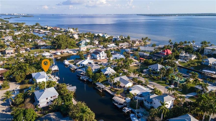This large, waterfront stilt house sits on a canal in St. James City just minutes away from open water and San Carlos Bay.  The oversized lot has lots of native vegetation, including mango, banana, lime, lemon and papaya trees, and a coral fountain making it an ideal place to while away the hours in the comfort of your back yard.  The ground level has a large storage/workshop area for your fishing tackle, boat & beach accessories, etc., and a kayak storage shed.  The two-story living area features a huge great room that is ideal for entertaining and two large full-width porches for the outside living that is Pine Island.  Inside you will find pull-out shelves in the kitchen, soapstone kitchen counters, custom master closet, spacious spa tub, and red birch custom cabinets in the den.  Check out the virtual tour and video to see much more.  Imagine living here right in the middle of all the boating, fishing, beaching on deserted islands, and everything else that Pine Island is famous for.  This could be your own private paradise!