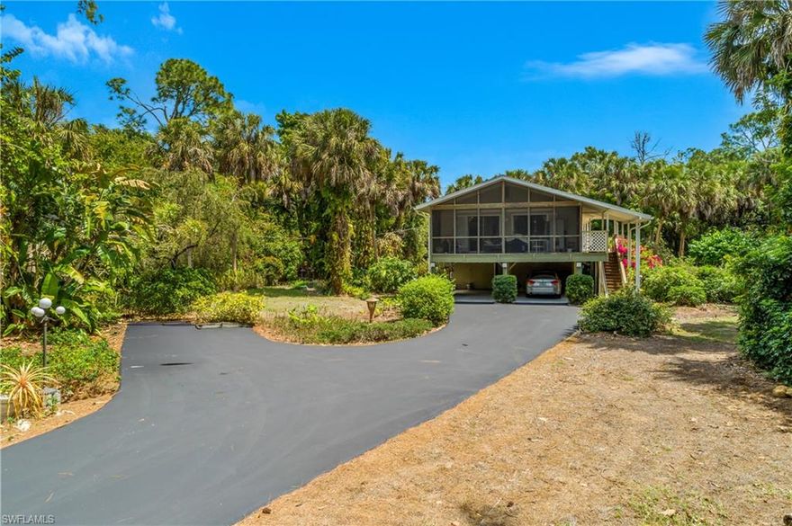 Discover the charm, privacy, and flexibility of Golden Gate Estates living on this beautiful 2.27-acre property featuring an original-owner stilt home with endless potential. Set deep into the lot for exceptional privacy, this residence offers the rare opportunity to enjoy the home as-is, expand it, or even build a new main house while converting the existing structure into a guest home — a highly desirable option in the Estates.

The home features 2 bedrooms and 1 bathroom, along with a large utility room that can easily be converted into a second bathroom. A standout feature is the ¾ wraparound porch, with the front portion fully screened and connected to the living area through sliding doors, creating a seamless indoor-outdoor lifestyle perfect for morning coffee, evening relaxation, or entertaining.
Below the main living level, the first floor includes a spacious workshop area with windows and sliders that open to lush landscaping, allowing you to enjoy the peaceful surroundings while working on projects, hobbies, or storage needs.
With 2.27 acres, the possibilities are endless — add a pool, build a larger primary residence, create a garden, bring your toys and animals, or design the outdoor retreat you’ve always envisioned. The property offers the perfect balance of privacy without sacrificing accessibility. This is a rare opportunity to own acreage in Naples west of Wilson with room to grow, customize, and create your ideal Florida lifestyle.