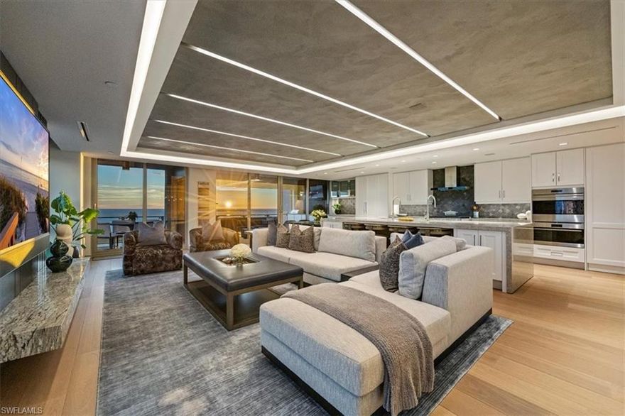 Welcome to 1701 Mystique, the crown jewel of Naples’ most prestigious high-rise, where custom craftsmanship and coastal sophistication meet on a grand scale. More than 5,500 square feet of reimagined living space capture sweeping views of the Gulf through floor-to-ceiling windows that flood the home with natural light.  One of Naples’ rare condos offering a private three-car garage plus an additional deeded space — four coveted parking spots in total. Every element has been thoughtfully curated—from Legno Bastone flooring and Venetian plaster ceilings to bespoke millwork and hidden cabinetry that add architectural refinement throughout. The great room is anchored by a dramatic stone and hammered-metal fireplace wall and complemented by a dedicated wet-bar, lounge, and 392-bottle temperature-controlled wine room—an ideal setting for both entertaining and everyday living. The gourmet kitchen features Wolf and Sub-Zero appliances, gas cooking, quartz countertops, and a striking Black Panther Leather stone buffet that blends artistry and performance. A spacious lanai with hurricane shutters includes a lounge area, dining space, and built-in grill, seamlessly extending the kitchen and great room for effortless indoor-outdoor living. The primary suite is a serene retreat with breathtaking beach vistas, a spa-inspired bath, and custom-designed closets for both beauty and function. One of the four additional bedrooms serves as a private office with 180-degree golf course views, and a hidden closet concealed behind a wall of built-in cabinetry. Smart-home comforts include remote-controlled drapes and blackout blinds in all bedrooms, dual dryers, and private elevator access. Mystique offers a lifestyle beyond compare with 24-hour concierge and staff, a resort-style pool, private spa suites, theater, fitness and wellness center, billiards and social rooms, guest suites, and tennis courts—all within Pelican Bay’s exclusive beachfront community, featuring two private beachfront restaurants and proximity to Naples’ finest shopping, dining, and cultural destinations. This is more than a home—it is a statement of design, exclusivity, and modern coastal living at its highest level.
