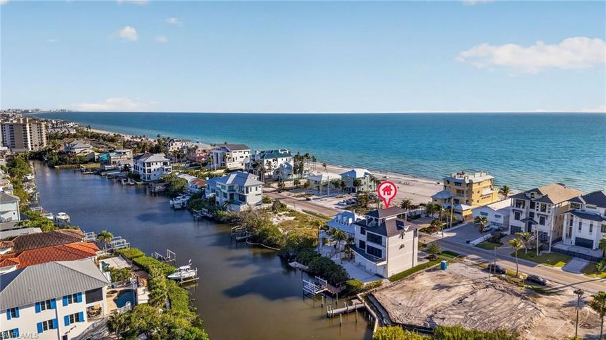 Sunrise over the bay. Sunset over the Gulf. Every single day. 27691 Hickory Blvd is a custom three-story residence on Bonita Beach designed for owners who don't want to choose between how they live on the water. 4 bedrooms, 3.5 baths, 3,243 air-conditioned square feet, and a private elevator. The main living level centers on a chef's kitchen with granite island, breakfast bar, custom wood cabinetry, all flanked by walls of sliding glass doors to a massive balcony above the bay. The first living level has two bedrooms that comfortably sleep 9 with a shared bathroom. Upstairs, a primary suite with spa like bath, and large walk-in closet. One more flight up to the rooftop observation deck — panoramic east-and-west exposures, with the bay glowing east at dawn and the Gulf burning west at dusk. Outside: A private dock and lift with deep-water access to Estero Bay, Wiggins Pass, and the open Gulf, and room to add a private pool. The detail worth saying plainly: this home has never been rented. One owner, one family, pristine throughout. And yet rentals are fully permitted — the investment upside is already built in, waiting for whenever you decide to use it. Steps to Bonita Beach. Minutes to Coconut Point, Mercato, Naples, and RSW. Take the tour and bring your boat.