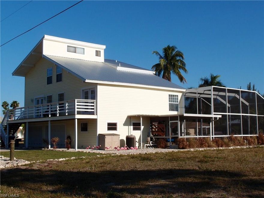 Immaculate waterfront gulf access pool home in a well maintained neighborhood of Manatee Bay. This spacious four bedroom modern home has it all. The home offers an open floor plan with plenty of space to spread out both inside and out. The interior offers a gourmet kitchen with stainless appliances, great room with cathedral ceiling, formal dining, and a master suite. There is plenty of storage with oversized garages and a bonus room. The exterior features a 20,000lb boat lift, a new fishing dock with a floating kayak launch and underwater light, a heated pool with a sun shelf, new metal roof and professional landscaping with zero maintenance yard. The screened porch off the kitchen is the perfect vantage point to watch the dolphin and manatee that frequent the canal and view the picturesque leaning coconut palm. Enjoy fresh mangoes from your own tree. A wonderful home priced to sell.