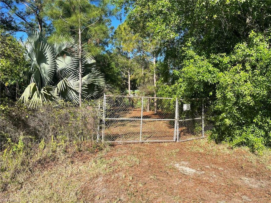 If you are looking for the perfect rural getaway, this may just be it. Come check out this fully fenced and gated 1.25-acre complex in Montura Ranch Estates, which includes a 1 bedroom/1 bath RV/travel trailer. Also included in the sale is a spacious, 40' container that houses a kitchen with both a refrigerator and microwave, as well as providing extra floor space for storage in addition to sturdy metal shelving. BONUS: various tools and a tiller also convey with the sale. The container has an electrical connection as does another outbuilding (10' x 10'), which is currently used as extra space as it has both a window AC unit as well as a portable AC/heater, but it could also be used as an office or workshop etc., There is even a small tiki hut that provides the ideal spot to just sit back and enjoy the privacy afforded this parcel of land. The property itself has a well (but no septic), and an established driveway and culvert in addition to a host of fruit trees such as mango and avocado. Mature coconut palms and three varying types of bamboo trees as well as a host of other native plants are found throughout. Call today to schedule your showing.