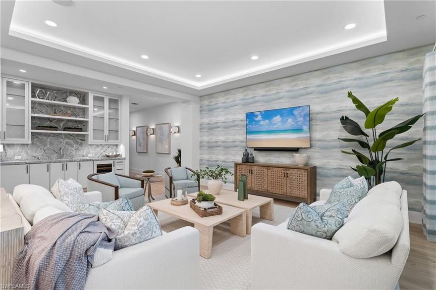 WALK TO 5TH AVENUE/DOWNTOWN NAPLES! A true one-of-a-kind! Welcome to Stella Naples, where luxury meets exclusivity in the heart of Olde Naples. Built in 2024 with only nine total residences (each with their own PRIVATE ROOFTOP DECK), this newly constructed boutique building redefines upscale, low-density living, just steps from the world-renowned 5th Avenue South, historic Downtown Naples, and the white sandy beaches of Naples. Unit 301 is an extremely unique residence consisting of two units that were combined during original construction and offers nearly 4,100 square feet under air, 4 bedroom suites (each with a private ensuite bath), den, music room, 4.5 baths, two covered lanais (with motorized roll down privacy/bug screens) each with their own gas fireplace, and FOUR DEEDED PARKING SPACES underneath the building. This tastefully designed top floor, end unit condo offers an open concept floor plan with 10’ ceilings, 4 sets of sliding glass doors to the two lanais, and rich wide plank European White Oak wood floors that flow throughout. The Kitchen has been outfitted with custom Ruffino cabinetry, Cambria quartz countertops, top of the line appliances including a 48” eight burner GAS Viking range and Sub-Zero refrigerator/freezer. Just off the Kitchen is a generously sized walk-in pantry with Miele speed oven. The impressive wet bar is complete with a wine cooler, ice maker, and ample bottle/glass storage. The impressive primary suite features its own private lanai with gas fireplace, separate his & hers walk in closets with custom shelving/drawers, auxiliary washer/dryer, music room with hidden storage closet, bath with oversized shower & free standing soaking tub, and a private den. Accessed from within the condo, the private 1,000 sq ft roof top deck is the perfect spot to enjoy the Naples sunset or entertain family & friends around two fire pit areas or outdoor kitchen complete with a gas grill and refrigerator, creating the ultimate setting for sunset cocktails before dining at one of the many iconic restaurants here in Downtown Naples. A long list of special features can be found throughout: motorized shades on all windows; custom window treatments/curtains; custom wallpaper details; recessed lights in all rooms; reverse osmosis water filtration system; in-ceilings speakers; 8’ solid core doors with Emtek hardware; stained cypress wood ceiling accents on the lanais; custom Ruffino cabinetry with Cambria countertops; designer Brizo, Rohl & Kohler bath fixtures; and more! Residents of Stella Naples enjoy an exclusive collection of amenities, including a sunny Southern-exposure 24/7 heated pool, state-of-the-art fitness center with an outdoor turf area, and an elegant club room. The building also provides four deeded parking spaces, ample guest parking and state-of-the-art security, featuring facial recognition technology and smartphone-integrated video access panels. Experience the finest in Downtown Naples luxury living at Stella Naples.