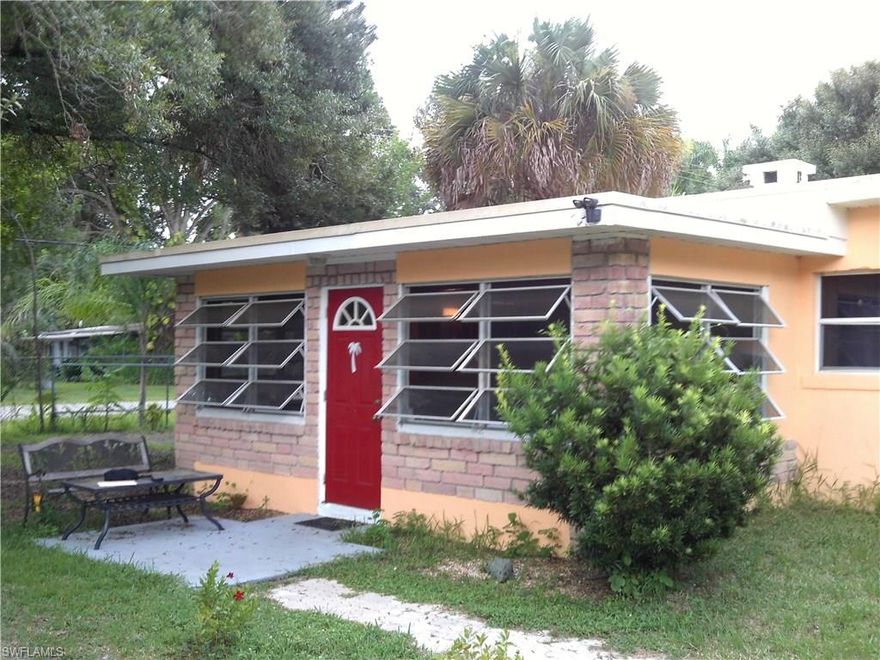 Adorable two bedroom, one bath cottage with old Florida charm. Masonry structure, 1950's vintage in the international architectural style. Desirable Alabama Grove setting north of Palm Beach Blvd & within a few blocks of the Caloosahatchee River. Easy access to downtown Fort Myers & all major routes. Oversized corner lot with mature palm trees, oaks, citrus trees, and native plants. Completely fenced yard perimeter with rolling access gates. Living room has arched openings & a working brick fire place. Additional front room has decorative exterior bricks, eight jalousie windows, exposed wood beam & wood ceiling. Bonus room in rear has tile flooring , drywall walls, & exposed rafters ceiling; now used as storage & laundry area but could be finished into an additional room. Flat roof was recently refinished and covered with hard rubber roofing. One  wall unit air conditioner. Many recent updates & some older items. A very versatile and functional home with great potential.