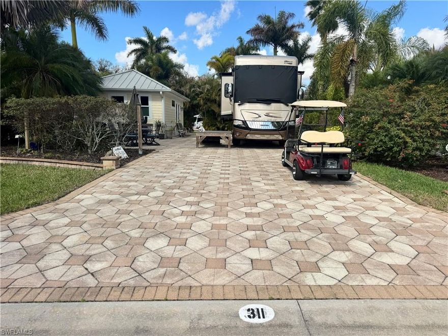 Looking for a large coach house in a prime location—close to the River Clubhouse, with no neighbors directly behind you, offering privacy, space, and a welcoming setting for your fur friends? You’ve just found it at lot 311. As you pull into this back-in lot, you immediately feel the sense of space and seclusion. Lush landscaping frames the property, and with no rear neighbors, your outdoor living feels open, peaceful, and wonderfully private. It’s the kind of setting where mornings start slowly with coffee in the sunshine and evenings end under a sky full of stars. Step inside the coach house and you’ll discover a layout designed for real living. The kitchen is a dream for the gourmet at heart, plenty of space to prep, cook, and entertain with ease. There’s a generous pantry closet, with the washer and dryer tucked neatly inside for convenience without sacrificing style. The bathroom features a full shower, and the bonus room offers flexibility for whatever suits your lifestyle—home office, hobby room or project space. It’s a coach house with options, and that’s what makes it special. Outside, imagine sun-soaked afternoons lounging with friends, evening cocktails with neighbors, and plenty of room for your four-legged companions to feel right at home. This lot was designed for both relaxation and connection. And the location? Truly ideal. Just a short stroll to the River Clubhouse, making it effortless to join in the fun. Wander over the charming footbridge to the main pool area where daytime energy fills the air and take a refreshing dip whenever the mood strikes. You’re close to everything, yet tucked into your own private retreat. Life at RiverBend Motorcoach Resort means you’re never short on options. With three clubhouses, you can spend afternoons poolside at the cabana bar, take a refreshing swim in the resort-style pool, unwind in the hot tubs, or enjoy riverside evenings with live music and themed dinners. Prefer to stay active? Join trivia night, gather for bocce, try Zumba or line dancing, or test your poker face at Texas Hold-Em. The lifestyle is vibrant, welcoming, and entirely up to you, be as social or as relaxed as you’d like. This isn’t just a lot. It’s a lifestyle upgrade. Pull in. Plug in. Let the fun begin. There is a golf cart that can be negotiated with purchase of property. Note it is not the golf cart in pictures.