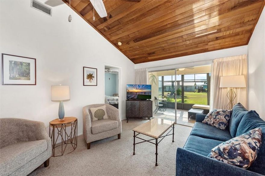 NO FLOOD ZONE! THIS is your slice of paradise! Adorable, UPDATED 2 bed/2 bath condo/villa, complete with covered parking and an additional storage closet. The spacious great room features a wood planked cathedral ceiling, leading to sliders that open up to the sun-drenched Florida room (furniture included!) that overlooks a park like courtyard view.  You will find both bathrooms completely updated, wood plank flooring in kitchen and baths coupled with durable berber carpet. Stainless steel appliances, NEW hot water heater 2026, NEW electric panel 2026, AC 2022 and newer roof and exterior painting.  This unit is also equipped with an in-unit FULL-SIZED stack washer and dryer for added convenience.  Enjoy a prime location with a community lake just around the corner and 2 community pools if you are looking for something peaceful and serene. Also centrally located to shopping, restaurants, health care, and the beach...and with LOW HOA and healthy reserves it makes it one of the most sought-after communities in Fort Myers.