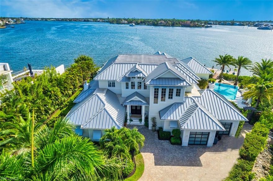 Offering spectacular waterfront living at it's finest is this crowning jewel of Jewel Box Avenue. Residing at the point of Chesapeake canal and Naples Bay stands this 4 bedroom en-suite estate with panoramic west facing water views from nearly every room. Owners will enjoy the first floor primary en-suite with 2 large walk in closets, huge primary bath with separate shower and soaking tub. Steps from the primary bed is a cozy outdoor sitting area with electric (remote controlled) retractable screens and shutters to enjoy the amazing sunsets over the bay. Guest will enjoy the second floor privacy with elevator access. Each en-suite has its own wrap around balcony access with spacious lounge areas and west facing water views. Additionally the second floor offers multiple en-suite wet bars, sitting area and media room that could easily be used as a 5th bedroom. Perhaps the star of the show is the nearly 8000 sq-ft of outdoor living space with waterfront infinity edge pool, 2 spas, outdoor kitchen, pool bath and multiple docks and boat lifts. Boaters will appreciate this section of Naples Bay is a no wake zone and the home resides well away from the  channel marked area thus offering peace and quiet calm waters.  Additionally the boat lifts have been strategically installed on the north canal side of the property offering further protection. The area has recently undergone extensive dredging and this property can dock larger vessels with a 24,000 lbs boat lift and 13,000 lbs jet ski/kayak platform lift. The list of upgrades to this home are extensive with a recent 7 figure renovation and refurnishing which WAS NOT a result of flooding or any storm damage. If you are looking for a well built turnkey waterfront property that lives like a high end resort 1340 Jewel Box should be considered.