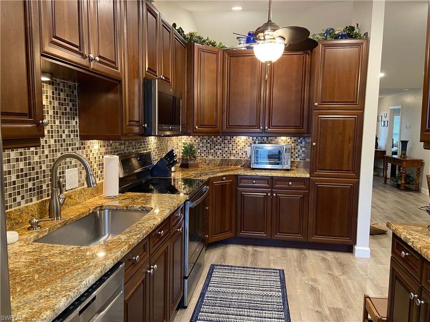 Welcome to Compass Pointe! Very well maintained 2 bedrooms, 2 baths, 1 car garage villa. Fabulous location that is close to shopping, restaurants, and entertainment, within walking distance to McGregor Blvd, across from The Landings, and 10 minutes to beaches and downtown Fort Myers. This end-unit villa in the highly coveted Compass Pointe neighborhood is on a dead-end, cul-de-sac. The kitchen is fully remodeled with granite countertops, LED recessed lighting under the kitchen cabinets, new GE Profile appliances, remodeled bathrooms, modern fixtures and ceiling fans, waterproof laminate throughout the villa, new gutters, new fascia, Nest doorbell, Yale door lock, private fenced-in area, tiled and newly screened lanai/front door area, large front, and side yards. AC was replaced in 2017. New filters and serviced as of Sept 4th, 2021. There is a small dog door going out to the 1-car garage. The electric panel has new breakers and is up to date. There are 2 attic accesses - one with stairs and one without. A reinforced floor and light in the attic were installed. Lots of attic storage! Laundry room is in the garage along with a sink and cabinets for storage. Very low HOA fees include yard maintenance, garden areas, exterior painting, and a community pool.