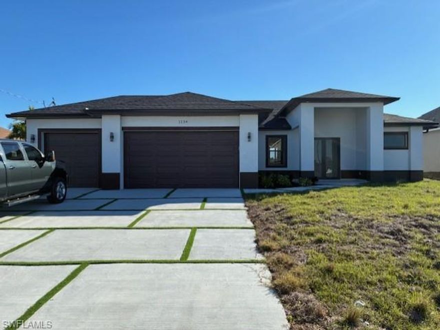 Brand new canal-front home in Northwest Cape Coral featuring 3 bedrooms, 3 full bathrooms, and a 3-car garage. This modern new construction offers an open-concept layout with high-end finishes and contemporary architectural design throughout. The bright living area showcases oversized porcelain tile flooring, tray ceilings, and impact windows and doors that fill the space with natural light. The modern kitchen features a large waterfall island, quartz countertops, sleek cabinetry, an electrical cooktop, and all appliances included, ideal for everyday living and entertaining. The primary suite offers peaceful canal views, direct access to the covered lanai, and a spa-style bathroom with dual vanities, a freestanding soaking tub, and a glass-enclosed walk-in shower with modern fixtures. Additional bedrooms are generously sized, and all bathrooms feature clean, modern finishes. Enjoy indoor-outdoor living with a covered lanai overlooking the canal, perfect for relaxing or entertaining while enjoying the water views. The spacious backyard offers room for a future pool or custom outdoor living area. Located in a growing Northwest Cape Coral neighborhood surrounded by newer homes, with convenient access to main roads, shopping, dining, and everyday conveniences. No HOA. Move-in ready new construction offering modern design, canal views, and exceptional value.