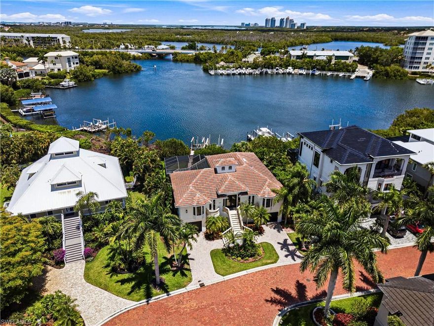 One or more photo(s) has been virtually staged, AI generated or rendered.  One or more photo(s) has been virtually staged, AI generated or rendered. Beautiful bayfront residence with direct Gulf-access ideally situated within the exclusive double-gated enclave of Southport on the Bay in North Naples’ highly coveted Barefoot Beach community. A true paradise for boaters and beach lovers alike, this exceptional property offers direct Gulf-access from your private boat dock with dual lifts, just minutes to open water and only a short five-minute walk to the sugar-white sands of Barefoot Beach. This beautifully maintained home features 4 bedrooms + den, 3 bathrooms, a 2019 tile roof, and tile flooring throughout. The spacious kitchen is appointed with light cabinetry and a breakfast bar for casual dining, flowing seamlessly into a bright sitting area surrounded by expansive windows that fill the home with natural light and showcase the stunning bay views. Step outside to the expansive balcony where panoramic bay views create the perfect backdrop for outdoor living and entertaining, overlooking the resort-style pool and spa with a spacious covered lounging area below. The primary suite offers private lanai access through French doors and features an ensuite bath with dual vanities, a glass-enclosed shower, and a separate soaking tub. Optional membership to the exclusive Club at Barefoot Beach provides access to tennis courts, two restaurants, and beachside and poolside food and beverage service. Ideally located near world-class dining, upscale shopping at Mercato and Waterside Shops, Southwest Florida International Airport, and just a short drive to the renowned Fifth Avenue South.