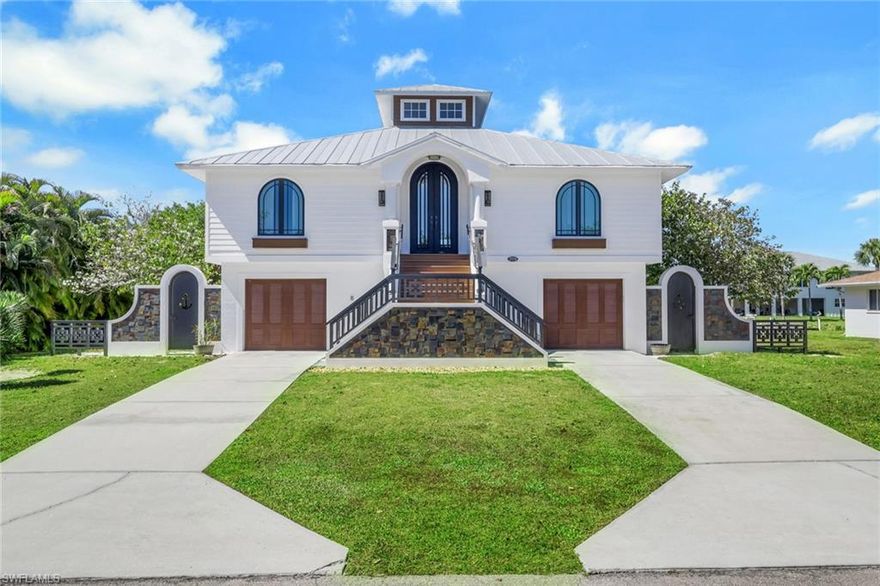 Situated within the peaceful enclave of Hidden Cove along the historic Imperial River, this exceptional waterfront residence showcases remarkable craftsmanship and architectural distinction, blending a coastal farmhouse façade with the timeless elegance of plantation-inspired riverfront design. Fully renovated in 2022 with meticulous attention to quality and structural integrity, this gulf-access property offers a rare combination of refined construction and idyllic waterfront living. A dramatic entry begins with an impressive sculptural staircase composed of nearly eight tons of poured concrete accented by hand-cut, inlaid slate, setting the tone for the thoughtful design found throughout the home. Inside, soaring 20-foot ceilings rise to a light-filled cupola encircled by windows, allowing natural light to cascade through the open living space and highlight the home's custom finishes. A striking twelve-foot front door welcomes the morning sun, while expansive riverfront sliders create the sensation of being aboard a luxury yacht as they frame sweeping water views and unforgettable sunset skies. Designed for both comfort and coastal adventure, the property features an 80-foot seawall, a 3,500-lb Golden boat lift, and direct gulf access, making it a boater’s dream. The ground level offers two spacious garages along with a dedicated golf cart bay—perfect for quick trips to the shops, restaurants, and live music venues of nearby Downtown Bonita Springs. This beautifully crafted three-bedroom, two-bath residence sits on a quiet road with no homes directly across, enhancing both privacy and tranquility. The home is offered with architectural plans for a future detached boat or guest house, presenting a rare opportunity to further enhance this extraordinary riverfront retreat.