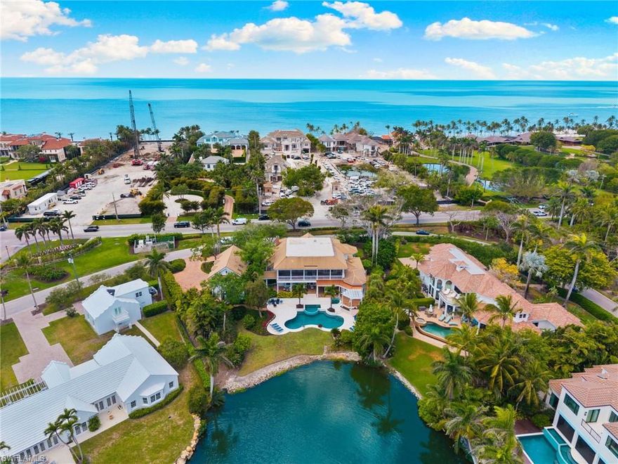 Stunning, spacious living in a home that is classic in style but has a southern flair.  An ideal location that is walking distance to the beach, close to Third Street South and Fifth Avenue South, for world-class restaurants, shopping, entertainment, art galleries, and more.  A distinguished estate with wrap around porches, and more than 3,000 sq ft of outdoor living space suitable for relaxing and entertaining.  The rear of the house has a stunning view of Lantern Lake, and the house is surrounded by exquisite landscaping and brick walkways.  The gormet kitchen is sui-table for entertaining large groups or just for private dinners.  Wolf Sub-Zero appliances, two Viking wine refrigerators, and a bar.  Two master suites, with one being on the ground floor and the other on the second floor.  Also of note is a 32kw generator for back-up power.  No detail has been missed in this extraordinary estate home.