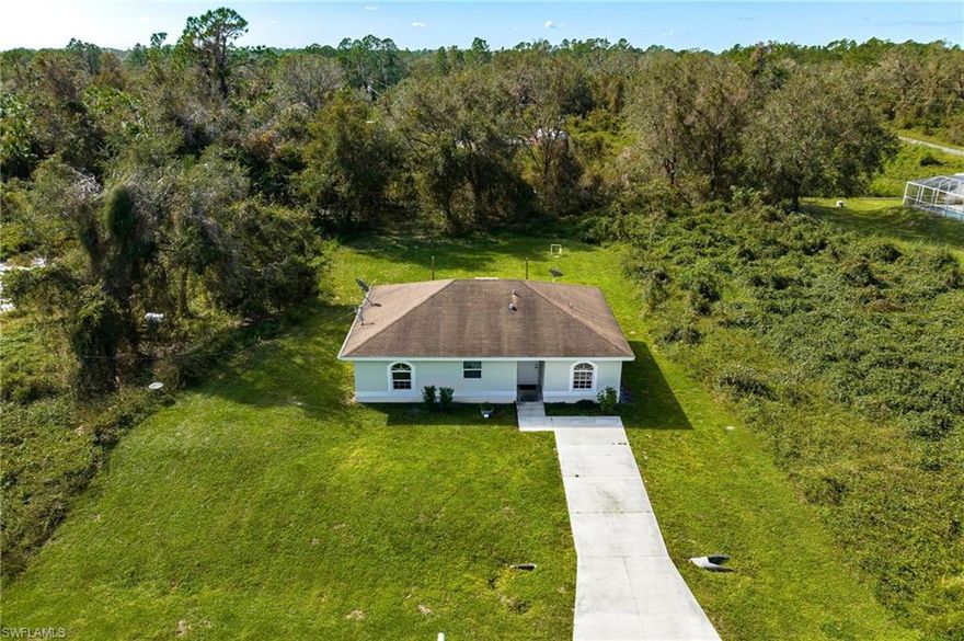 Concrete block 4-bedroom, 2-bathroom home available in Lehigh Acres!  This recently constructed (2008) home sits on a .28 acre lot and boasts coveted southern exposure.  The private backyard is surrounded by beautiful mature trees and greenery.  No restrictions or HOA fees!  NEW EXTERIOR PAINT in September 2022. Located within minutes of Hickey Creek Mitigation Park, River Hall Country Club, and Buckingham Farms.