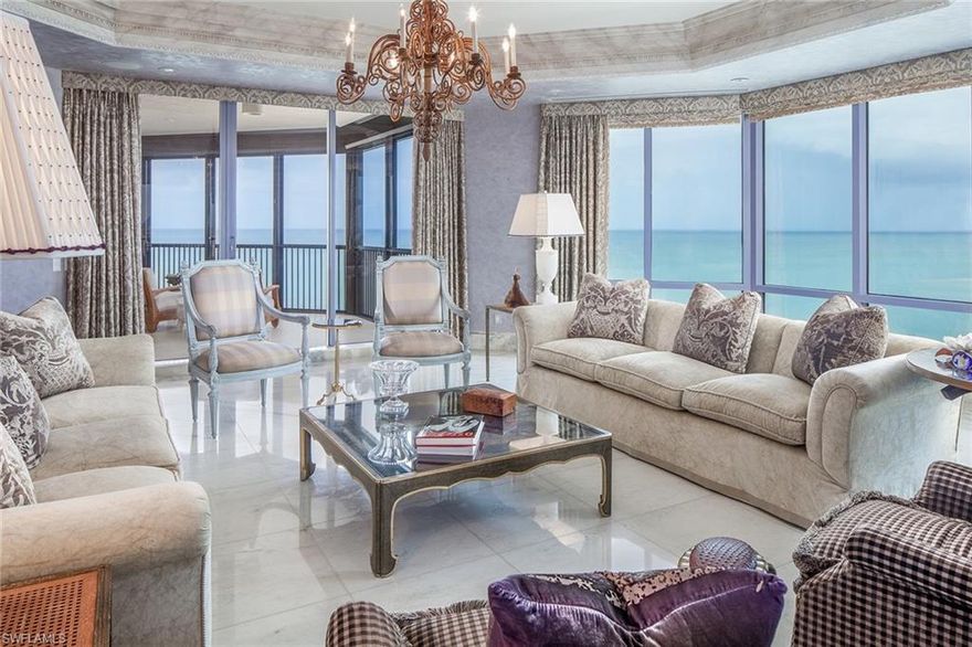 This 6,085 square foot four-bedroom, four-and-a-half bath luxurious beachfront condominium dazzles the eye. Designed in Neoclassical elegance with French/Asian accents by world-renowned designer, Juan Pablo Molyneux, showcasing the unparalleled and ever-changing views from every room and three balconies. Juan Pablo is known for his architectural symmetry, with the talent of mixing historical reference with contemporary and quality finishes, includes rare Italian marble flooring, casings, columns, onyx baseboards, custom Hyde Park plaster moldings, Montavano finished walls, by the best artisans in their craft.  This home features a serene master suite with his and her separate baths, three guest bedroom suites, Koa wood-paneled library, formal dining, family room with cherry custom millwork open to an expansive kitchen, butler's pantry and breakfast area. Windsor, the premier building in exclusive Bay Colony, is the only Naples gated beachfront community with private tennis facility and newly renovated beach club.