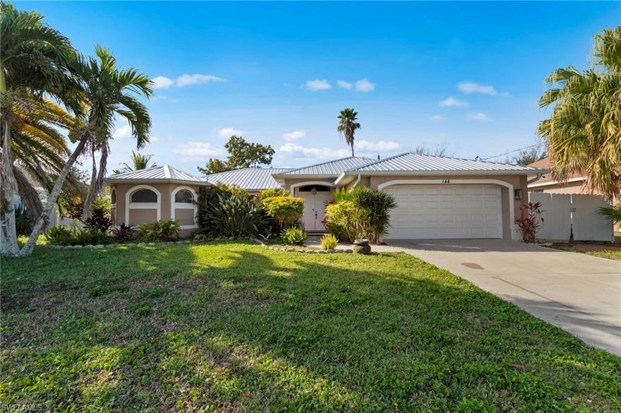 Discover the perfect blend of comfort, convenience, and opportunity with this inviting 3-bedroom, 2-bath home in beautiful Cape Coral—one of America’s fastest-growing cities. Offering approximately 1,659 square feet of living space and a two-car attached garage, this well-maintained property is ideal for first-time homebuyers, investors seeking rental income, seasonal residents, or those looking to downsize without sacrificing space or style. Best of all, there are no costly HOA fees. From the moment you arrive, you’ll notice the charming curb appeal highlighted by mature trees and established landscaping. A welcoming double-door entry with an arched transom window leads into a bright foyer that sets the tone for the home’s open and airy feel. Inside, beautiful tile and hardwood flooring provide durability and easy care while complementing the home’s warm and inviting atmosphere. The spacious family room features a soaring vaulted ceiling and an open layout designed for both everyday living and entertaining. Double windows and large sliding glass doors flood the space with natural light and lead directly to the covered lanai, seamlessly blending indoor and outdoor living. The corner breakfast bar keeps the kitchen connected to the main living area so everyone stays part of the conversation. The kitchen is thoughtfully designed with beautiful cabinetry, abundant counter space for meal prep, and sleek stainless steel appliances. Whether hosting guests or preparing a quiet meal at home, this space is both functional and stylish. Step outside to the covered and screened lanai, where a tiled floor creates a peaceful retreat perfect for relaxing with your morning coffee or unwinding in the evening. The fully fenced backyard (w/two side gates for easy backyard access) is spacious and private, filled with lush green foliage and mature landscaping that provides a serene backdrop for outdoor living. The primary suite offers generous space to relax and recharge, while the en-suite bathroom features dual sinks, a separate soaking tub, and an easy step-in shower. Two additional bedrooms are comfortably sized and perfect for family, guests, or a home office. Additional highlights include a newer metal roof for long-term durability and peace of mind. Ideally located close to shopping, dining, parks, theaters, and vibrant downtown areas including Fort Myers. Enjoy easy access to the white-sand beaches of Fort Myers Beach and Sanibel Island, as well as nearby Southwest Florida International Airport. This is Southwest Florida living at its best—comfortable, convenient, and full of potential.