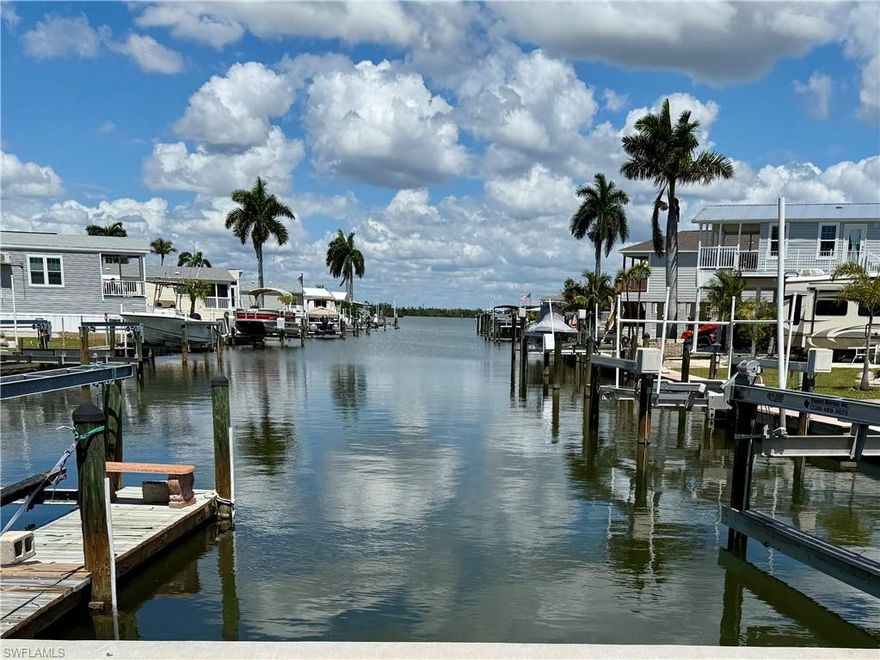 spacious lot on a canal location which offers a great opportunity to build an exceptional elevated home. This Lot orientation offers a rear facing long canal view minutes from the pristine Estero Bay. There are currently many smart owners who recognize the opportunity to enjoy low fees with amenities in this 55+ community.  Port Carlos Cove is an active lifestyle boating community geared to those who want to live life fishing, boating, exploring the back bays & socializing in a beautifully refurbished clubhouse with amenities. Amenities include: New Community Pool & renovated clubhouse, Pickle Ball, shuffleboard, Bocci, and an active social club. LOW HOA FEES-yes--$200 PER MONTH includes: Water, sewer, irrigation, seawall, landscape, pool maintenance. A two minute commute to the unparalleled, pristine Estero Bay awaits. If you own an RV, you will be able to keep it on your parcel while you design your home!  Conveniently located very close to great restaurants and on a canal that is dredged in perpetuity by Lee County! Zoning options include stilt build or Modular style home. Please note that the modular home shown as depicted are presented on this site are for suggestion purposes only. Dramatic Miami style design plans are available with several flexible buyer options if you are interested. Lot will provide a spacious 2/3 bed/2 bath home + ample room for a design with  back sitting area overlooking the canal and will provide ample parking & easy placement of stair access.  Port Carlos Cove resides in Lee county jurisdiction; no impact from Ft. Myers beach restrictions! Also, the reinforced bulkhead on site is well maintained. As an owner, you will enjoy an easy cruise to explore & fish the back waters of the renown ESTERO BAY, PLUS DIRECT GULF ACCESS WITH NO BRIDGES! Port Carlos is perfect community to grant dramatic views where you will see Bald Eagles, Osprey, manatee, spotted eagle rays, Dolphins, fish jumping & more. Port Carlos Cove community is a very unique & rare property. It is defined as: 45 acres surrounded by an environmental preserve with its own canals and over a mile of seawall. Where else can $200 HOA a month can you own a property in such an area with its own boat ramp and dock, clubhouse with Pool, Shuffleboard & pickle ball courts, "back 40 acreage" spacious storage area for boat, Utility trailer, RV or extra car storage? Also, Port's Compound area: free lawn and landscape service, and trash disposal, water and sewer. lot INCLUDES a large ADDITIONAL protected area for parking and storage+ on this 16-acre site assigned to each resident for your trailer/camper (INCLUDED with your Deed).. Port Carlos Cove 55+active lifestyle, co-op community allows limited rentals (30 days-6x per year). INCREDIBLE- WALK to Ft. Myers Beach & Margaritaville, Key West Express terminal, & 2 Caribbean feel restaurants; plus a pirate ship! a five min drive offers Endless fun times on Ft Myers Beach!  NOW is the time to consider this property!