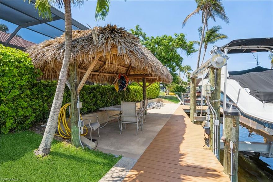 Absolutely Stunning Turn-Key 4 bed/3 bath + Den Pool Home on Sailboat Access Canal. Every Boater's Dream, access to the Caloosahatchee River is just Minutes away! Dock area offers a large Tiki Hut, 10,000 lb Boat Lift/Canopy and Captain's Walk.  Boat is available for purchase.  Home is located in a Quiet Neighborhood on a Cul De Sac. Double Entry Doors invite you into a Gorgeous Open Floor Plan and Huge Family Room. Kitchen has Granite Countertops, Decorative Cabinets, Counter Bar, under Cabinet Lighting,  Stainless Steel Appliances including a Smart Screen Refrigerator, Pantry and Eat-in Area.  Pocket sliding doors lead you to a large screened in Beautiful Lanai area, Outdoor Kitchen Grill w/Commercial Hood, Granite back Splash/Countertops and Bar Seating.   Home exhibits Tray Ceilings and Crown Molding everywhere. Large Laundry Room has Built in Cabinets and is located off of the 3 Car Garage.  Salted Pool is Heated w/ a Raised Spa. Plenty of Deck Space to Enjoy the Sun.  New pool pump, heater, screens, and salt chlorinator. for pool.