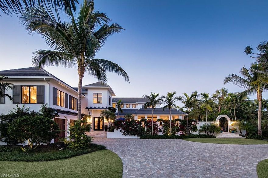 A sophisticated home masterfully executed by the team of Kukk Architecture and Design, P.A. and A. Vernon Allen Builder, Inc. Comfortable inner spaces flow with calming transitional areas to enjoy the lush surroundings of an exceptionally large Old Naples property (.6 acres per plat and deed) which is just a stroll to the Gulf of Mexico. The chef’s kitchen with hand-crafted zinc hood, twin islands and a 60” Wolf stove make it a space for both serious cooking and for entertaining. The generous master suite offers separate bathrooms, steam shower, deep-soaking tub, wet-bar, walk-in closet and sitting room. Enjoy your morning coffee on the master balcony overlooking a mango tree and lush tropical landscaping. The outdoor kitchen and adjacent sitting area, with motorized screens and hurricane shutters, provide the perfect outdoor gathering area. This stunning home comes equipped with a full-house 48 KW generator, water filtration system, impact windows and doors, an elevator which stops at all levels, laundry facilities on the main and upper levels, and Lutron lighting.