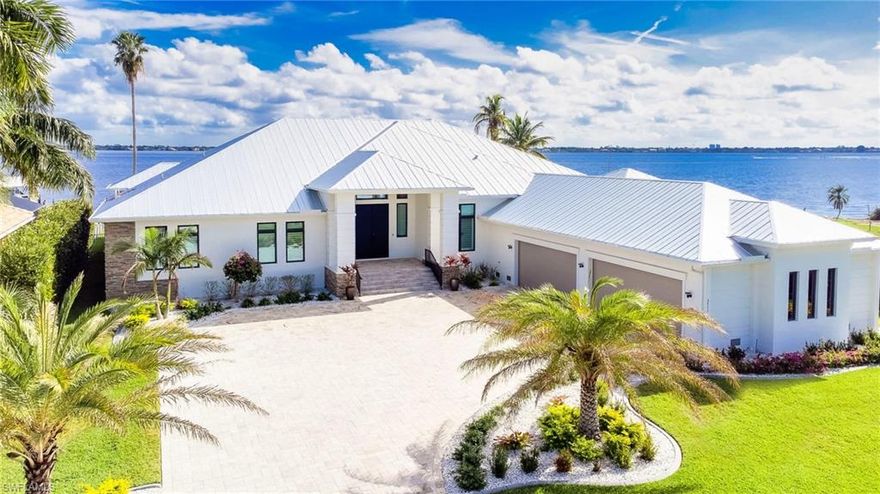 This is your chance to own a one-of-a-kind custom Cape Coral Riverfront Estate sitting on one of the largest single family parcels (¾ acre) in town. Completed in February 2021, this home is built on 59 concrete 10x10 inch 8-10 ton pilings. This contemporary Estate offers an unparalleled 4,781sqft of ground floor living area and a massive 12,064sqft total area incl 1,516sqft garage with min. 5 car and/or boat capacity. Enter through the massive steel doors into the 14ft ceiling Foyer and immediately take in the expansive river views highlighted by 80 feet of impact resistant 10ft high sliders throughout the living areas.  New 120ft seawall 2019, composite boat dock/lifts Oct 2020 w/ large sundeck & versatile platform lift that can accommodate 2 jetskis or boat/kayaks. Oversize 38x15 saltwater lappool w/SPA & sunshelf. Custom cabinets w/ quartz counters throughout the home. Spectacular master suite with luxurious in/outdoor showers, soaking tub & sauna. Two additional suites w/ private baths, riverviews & lanai/pool access. 1800sqft lanai with full outdoor kitchen, TV hook-ups & Kevlar storm shutters. Large lot & layout offers possible addition of extra living area/guest building