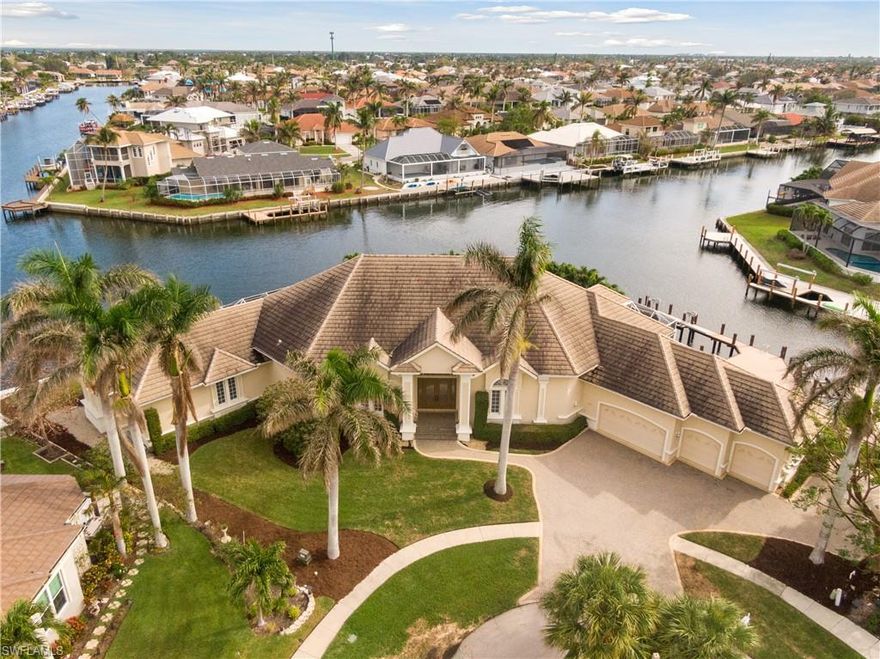 True boater's delight with over 311 feet on the water! 5 converging waterway views seconds to open water under Smokehouse Bay Bridge with 14' clearance. Renovated in 2016, this stunning home left no expenses spared! Quartz counters, upscale appliances, and beautiful finishes throughout! 4 bedrooms, 4 baths plus den and 4-car garage, 2 laundry rooms, just shy of 4,000 square feet under air and a total of 5910 square feet! This open concept floor plan is a great entertaining home boasting wet bar, ice maker and refrigerator in great room with separate formal dining area. Huge oversized lanai has 50-foot pool and spa with waterfall, outdoor kitchen and built-in grill. Garage has 20 feet of extra driveway on side of home. Extensive dock built in 2016 with 2 lifts. Enjoy peaceful living in one of the largest tip lot homes on Marco Island!