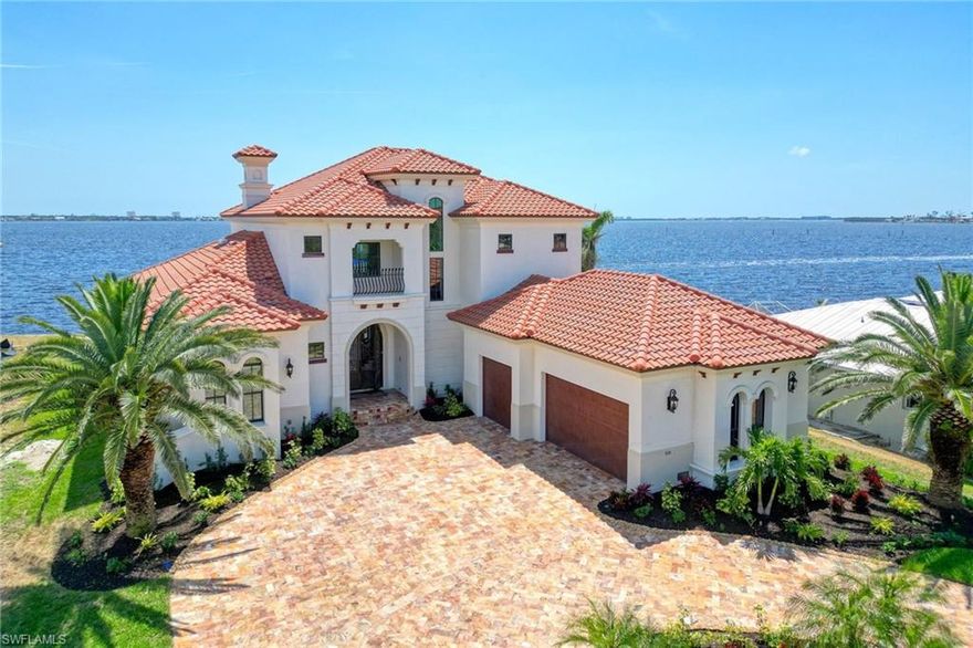 Welcome to a boaters paradise meets designer's dream home! This 5 bedroom, 5 bathroom waterfront estate home is located on the open Caloosahatchee River in the highly desirable Yacht Club area. Head out to the Gulf of Mexico from your backyard and watch the dolphins play all the way down the river. The stunning outdoor space is made for fun in the sun with the 26,000 lb boat lift with new dock, resurfaced infinity pool + spa, gas fireplace, new travertine pavers on the sun deck, & completely equipped outdoor kitchen. Every inch of the turnkey furnished interior has been custom designed with elegant touches throughout including the soaring 25 ft ceilings, Chef's kitchen with gas Viking range, custom refrigerator & appliances, Italian marble countertops, gas fireplace, Butler's pantry, wrought iron staircase, new interior paint, & impact resistant windows/ 10ft sliders. The stately curb appeal has been professionally enhanced with all new tropical landscaping, new exterior paint, travertine pavered circular driveway, double entry doors, and oversized 3 car garage. Enjoy your new slice of paradise right in the heart of Cape Coral! *All photos are current & photographed post storm.