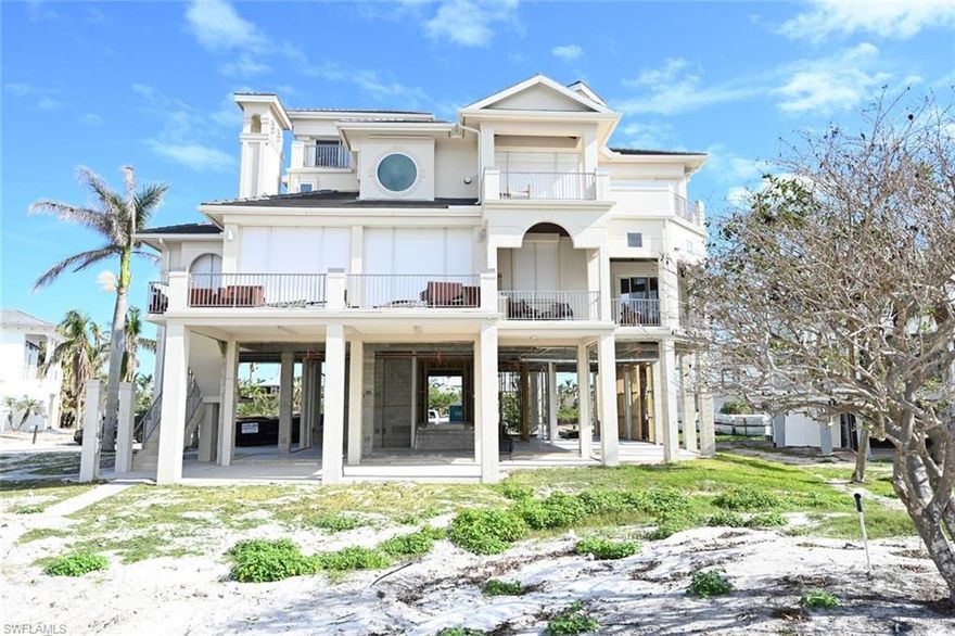 This four story Barefoot Beach home was constructed on two lots (4 & 5) and offers wide Gulf of Mexico views. Homes lower level was damaged in Hurricane Ian.  Sold As-Is and Seller not completing any repairs.