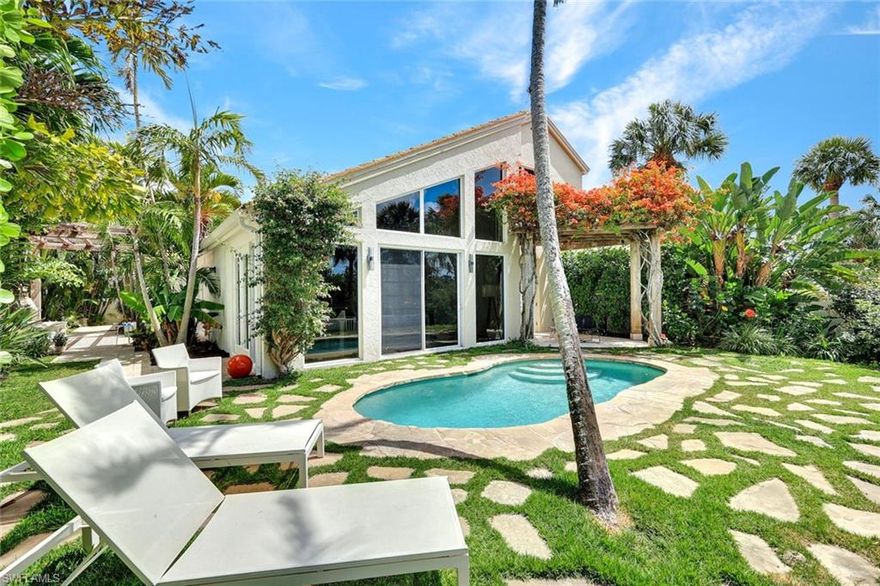 Unique and stylish...rarely available river-facing home in Anchorage at Bonita Bay. One of only nine homes in the community with coveted South and West facing views of the Imperial river, this property is perfectly positioned close to Riverwalk Park, offering tranquil breezes and serene water vistas. A multitude of updates enhance this home with contemporary coastal style. Recent improvements include beautiful Legno Bastone European Oak flooring throughout, a sleek new upstairs bathroom featuring custom cabinetry, and modern new stair railings that add architectural interest and sophistication. The open great room floor plan with soaring vaulted ceilings floods the space with natural light complemented by the custom mahogany front door. The spacious kitchen is appointed with Wolf appliances, a 5-burner gas cooktop, honed granite countertops, and custom cabinetry including a breakfast bar and built-in desk. Spa-like bathrooms feature luxurious stone finishes and multi-jet showers. Outside, lush bougainvillea-covered pergolas create inviting spaces for entertaining and relaxing, seamlessly blending indoor and outdoor living. Bonita Bay offers world-class amenities including a full-service marine, private beach club, miles of walking and miking trails, multiple recreation parks, and tennis and pickleball - all just steps from your front door. This is your chance to experience the best of Florida living in a sophisticated, move-in-ready riverfront retreat - offering all the charm of new construction coastal homes, at a significantly more compelling value.