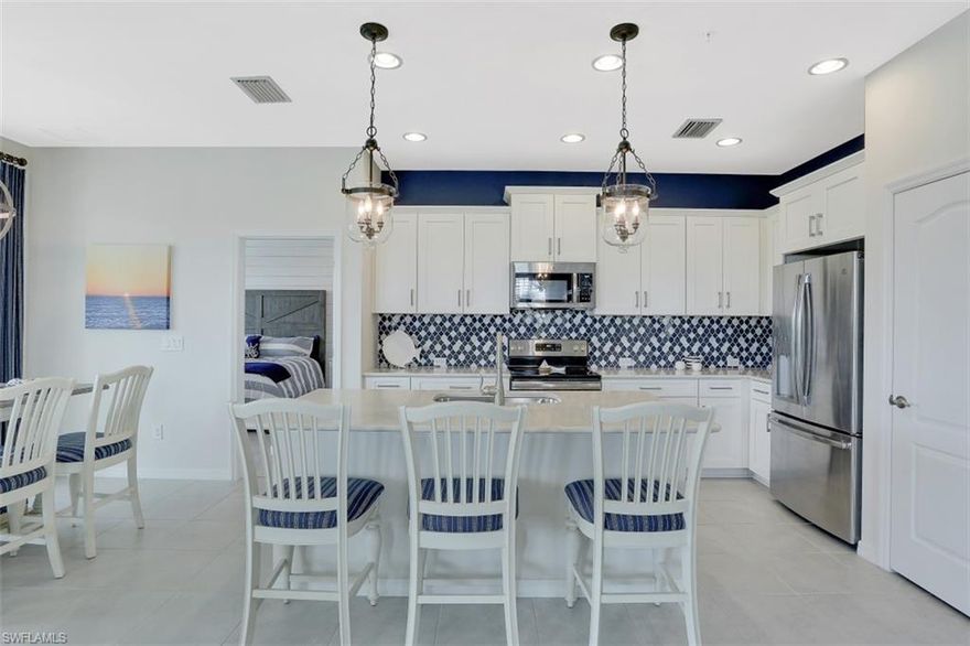 Two-years new AND with all the after build additions! As you walk into this 2 Bed + Den carriage home, it is clear that someone invested in beautiful & smart finishes as you take in the shiplap wall, plantation shutters, the navy accents, custom drapery, master closet built-ins, after-build backsplash, custom lights & fans, and remote controlled thermostat, door bell, garage door opener and indoor camera. Windemere plan offers two generous bedrooms + a large den. As an end unit you have great natural sunlight pouring in. Upgraded finishes such as quartz counters, large tile and white cabinets offer light and bright living. One of the best views. Oversized south-facing lanai overlooking the landscaped lake with water fountain. Impact windows/doors.

With only 13 buildings in the coastal-themed Richmond Park, you enjoy a peaceful and intimate setting. Being located in a growth area, there are many local attractions within a bike ride/walk including restaurants, shopping and soon-to-be-built social hub.

NOTE: Home is priced without furnishings, however, the owner is willing to leave the home furnished and/or turnkey as a separate purchase.