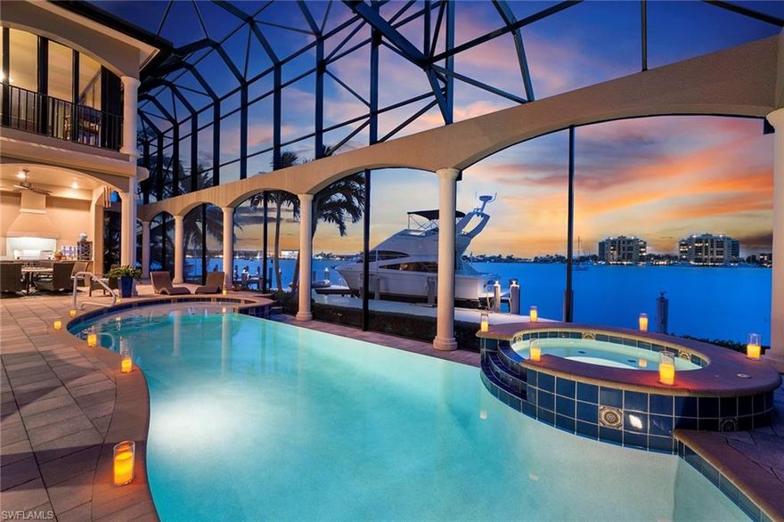 Sunsets, dolphins, birds, cruising boats all on the Marco River. Imagine waking up daily to the panoramic views of endless beauty from this luxurious custom crafted home by DIVCO. Turnkey furnished, over 5,600 SF under air,  welcoming double door entry, voluminous great room, coffered and tray ceilings all open to the lanai leading to the outdoor kitchen and fireplace, custom swimming pool and spa with sun shelf, infinity edge, panoramic stucco framed screened enclosure and paver deck. The 30,000-pound lift, 2005 seawall and oversized dock provide for a boater's dream. The gourmet kitchen has beautiful cabinets, granite counters, tumbled marble, a gas range, KitchenAid appliances and a built-in Miele coffee maker. A very special feature is the Wine Room with two wine refrigerators. Master Suite offers Lanai Access, Sitting Area, His/Hers CA Walk-In Closets, His/Hers Vanities, Jetted Tub/Walk-In Shower. Ascend the Staircase to Media Room with Movie Screen/Wet Bar, Game Room with Billiards & WALLS OF IMPACT SLIDERS. 3 Car Garage, Audio System, 3 AC Zones, 25KW Generator & Fine Furnishings Complete the 7,552 SF Timeless Beauty!